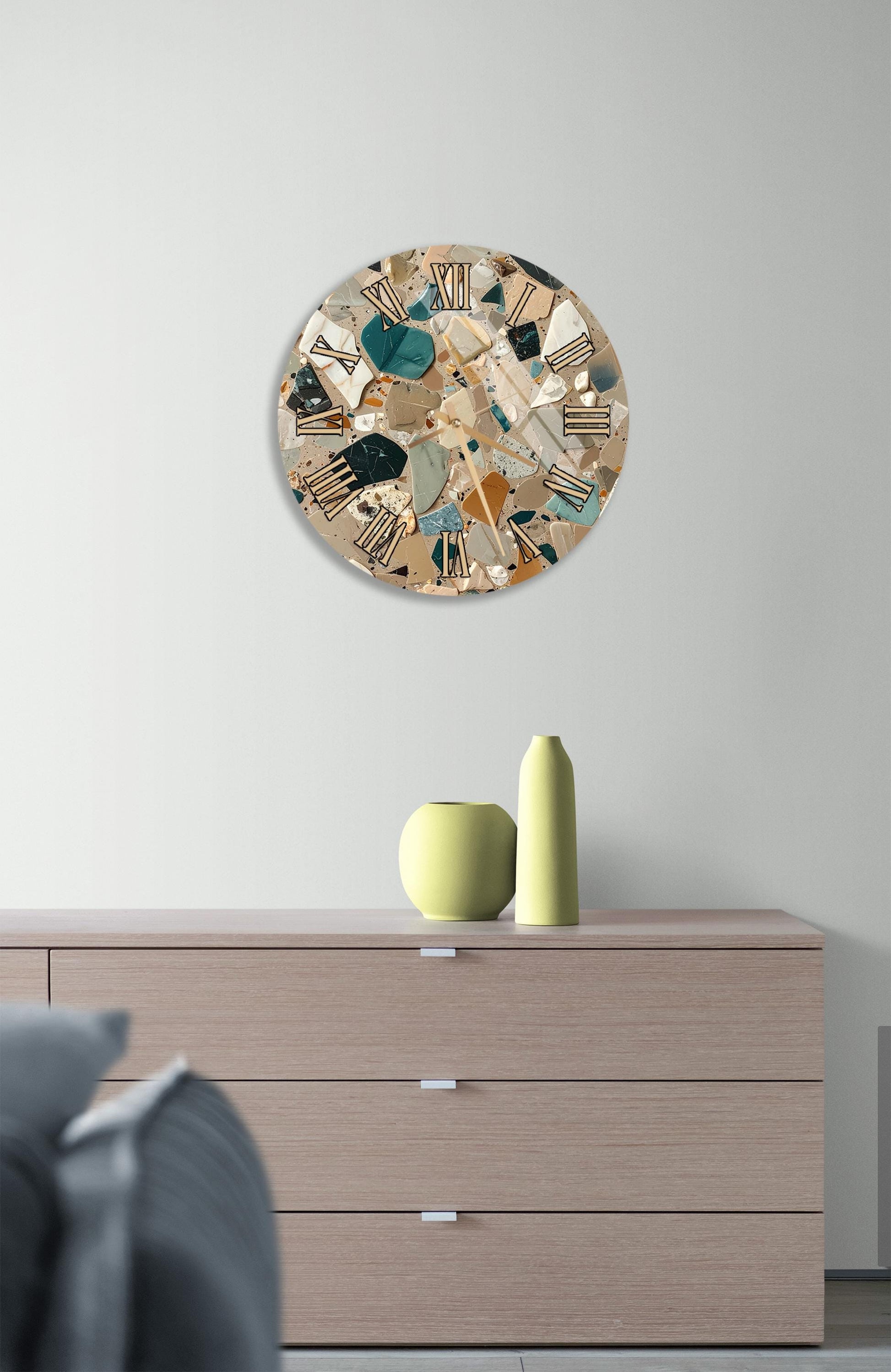 a modern interior design with a wooden dresser, a round clock with a mosaic design, and a yellow vase on the dresser.