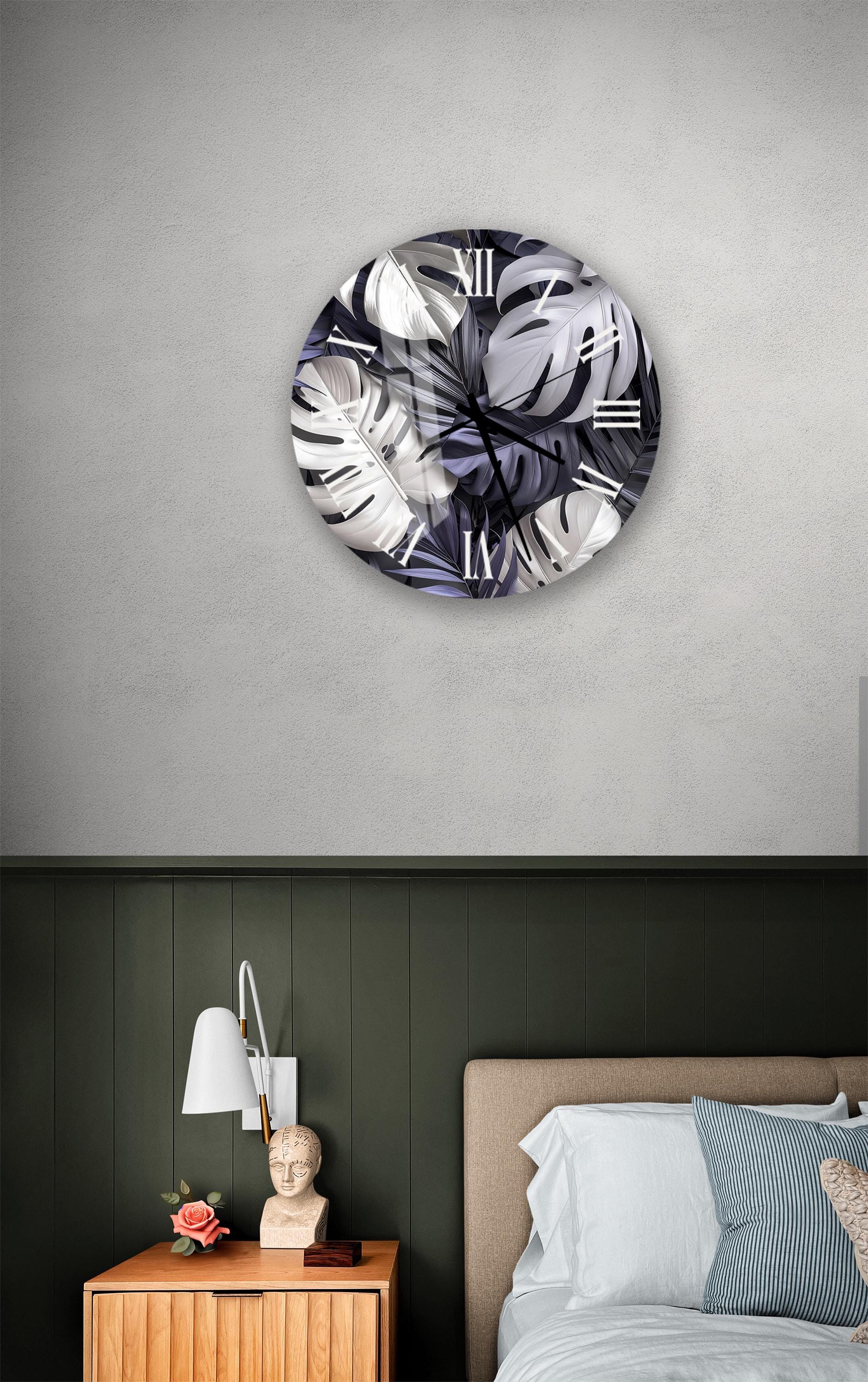 a bedroom setting with a round wall clock displaying a leafy plant design, a wooden nightstand with a lamp, and a bed with white bedding.