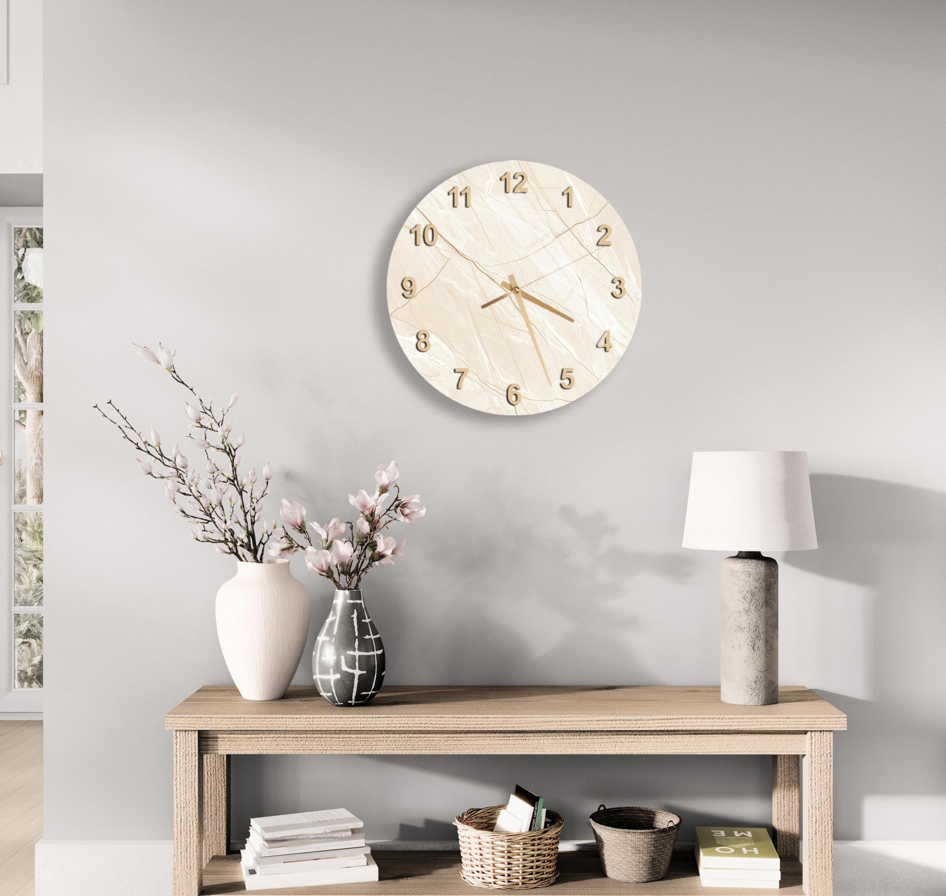 a minimalist living room with a round wall clock, a wooden table with a lamp, a vase with flowers, and a stack of books.