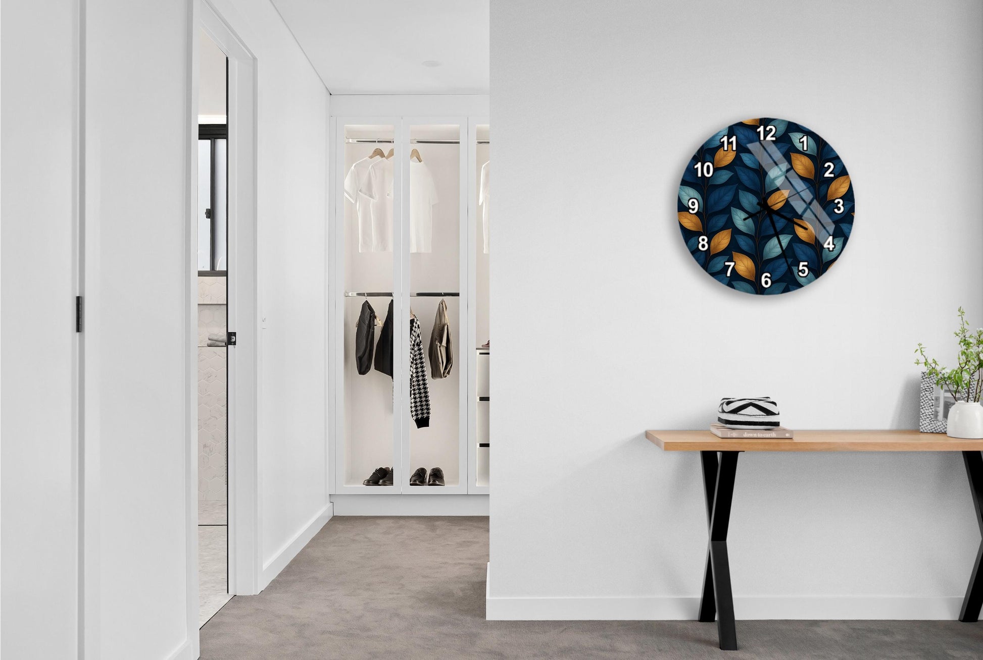 a hallway with a wooden console table, a wall clock, and a closet with hanging clothes.