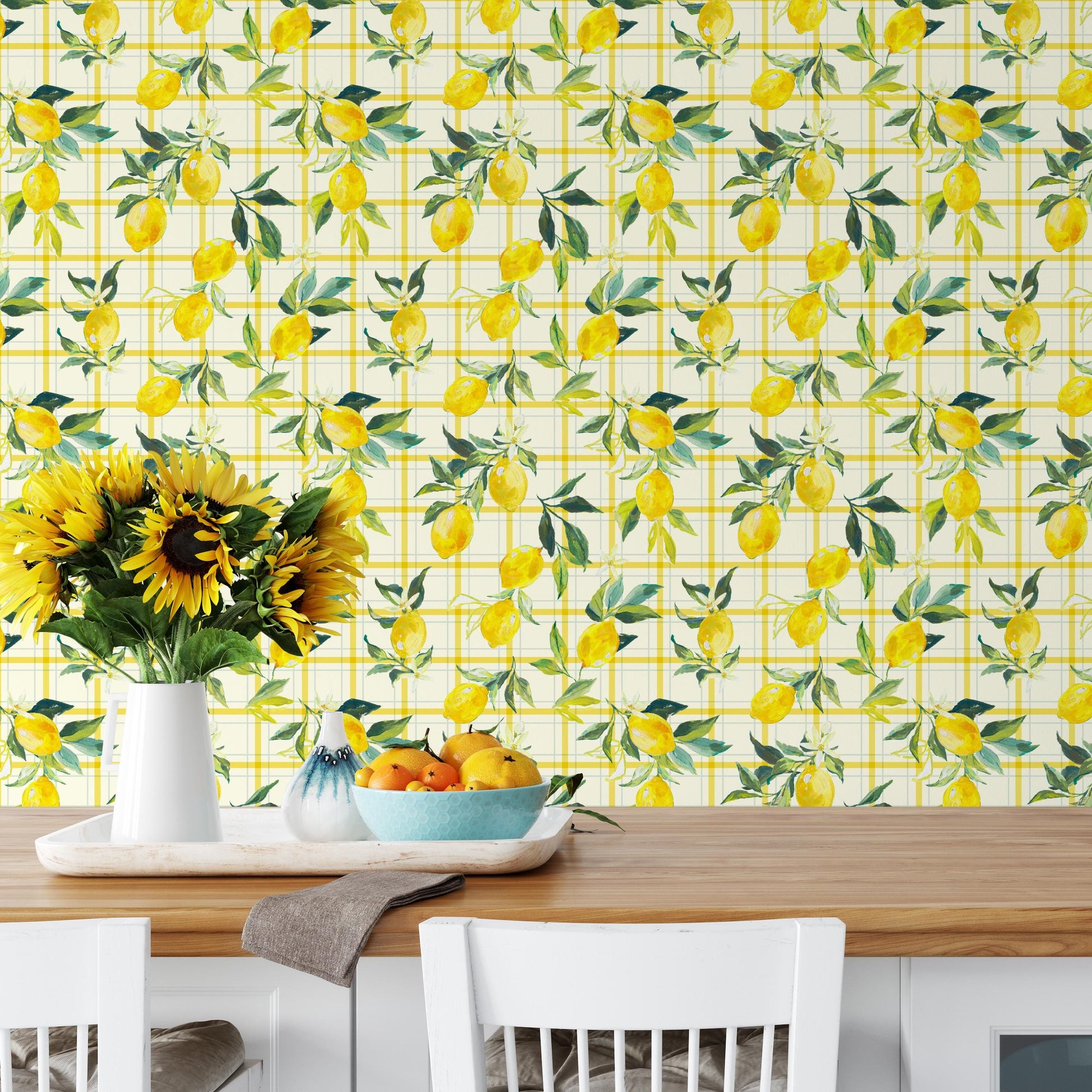 a dining table with a vase of sunflowers, a bowl of fruit, and a white chair. The table is set against a wall with a yellow and green checkered pattern.