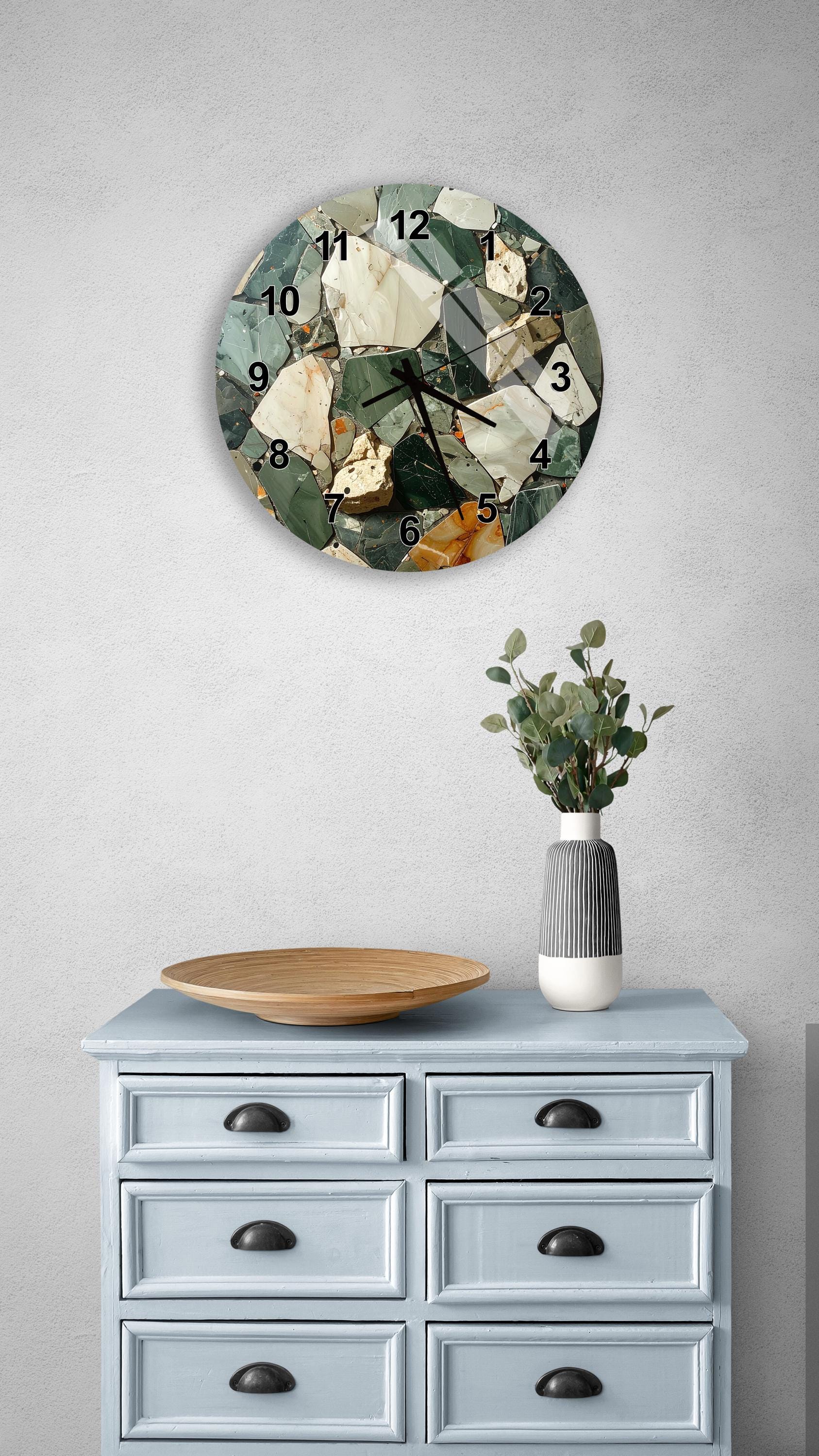 a wall clock with a mosaic design, a wooden tray, a vase with greenery, and a light blue dresser with six drawers.