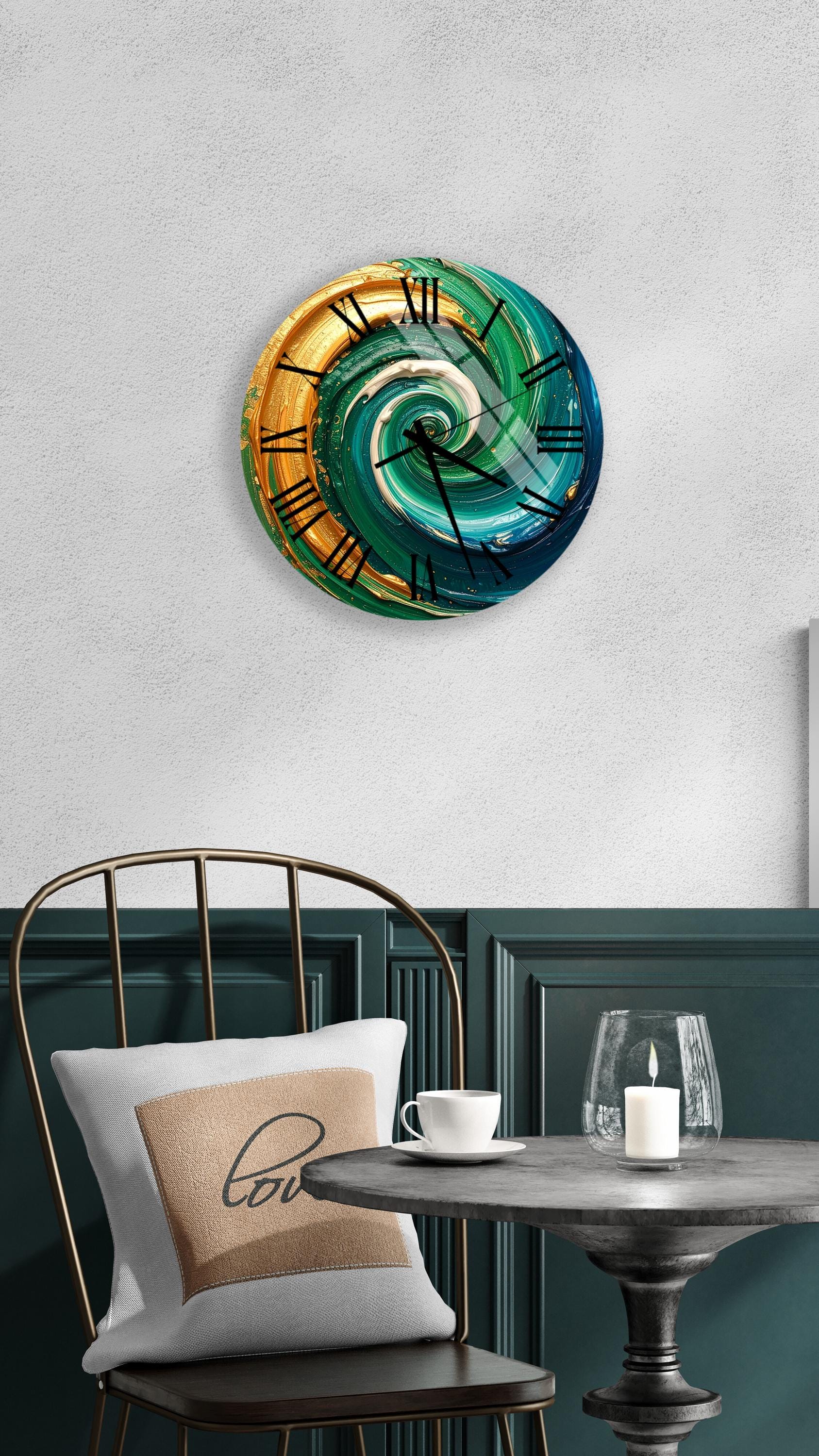 a wall clock with a swirling design in gold, blue, and green colors, mounted on a white wall above a dining table with a white tablecloth.