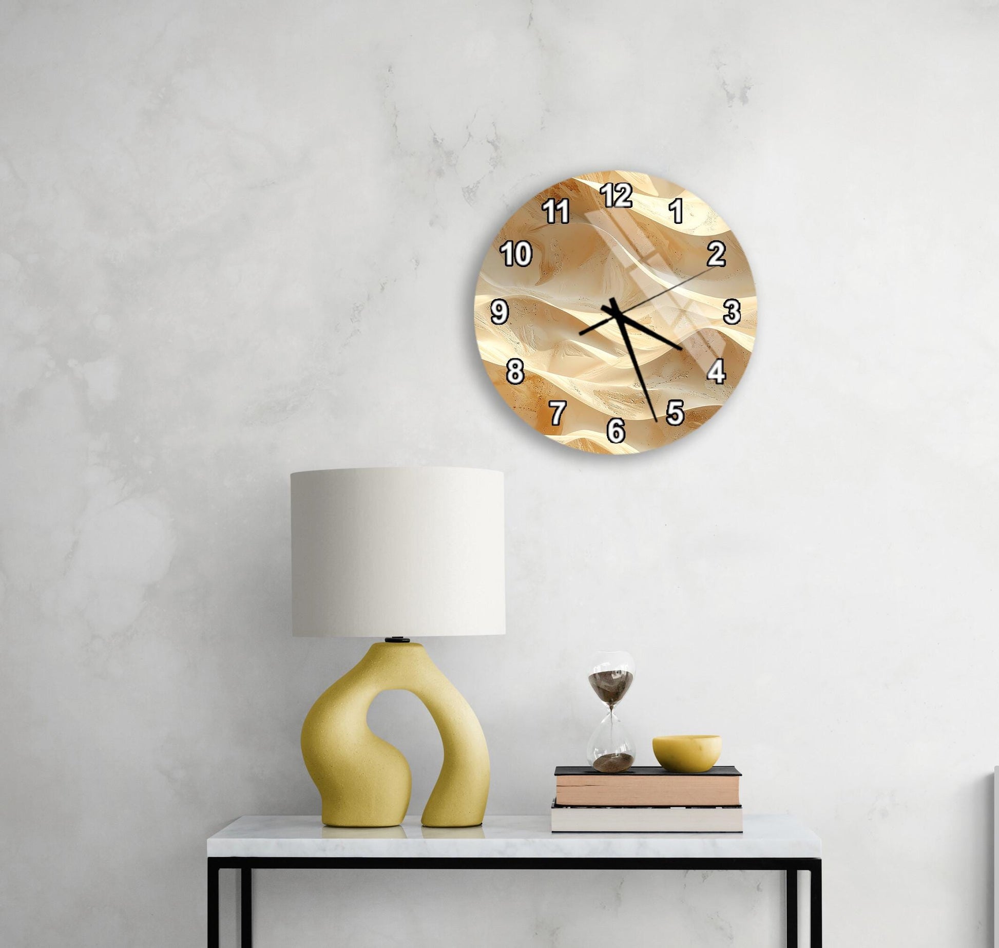 a modern living room with a white marble wall, a round clock with a gold-colored design, a yellow lamp with a unique curved base, and a small table with a book and a glass of water.
