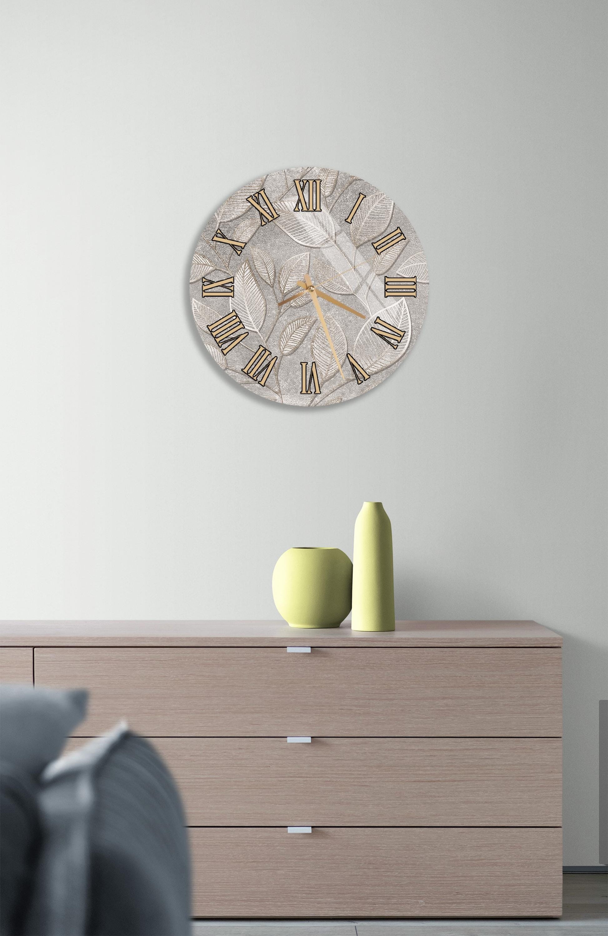 a modern living room with a large wall clock displaying Roman numerals, a wooden dresser with a vase and a small green sculpture, and a gray couch in the background.
