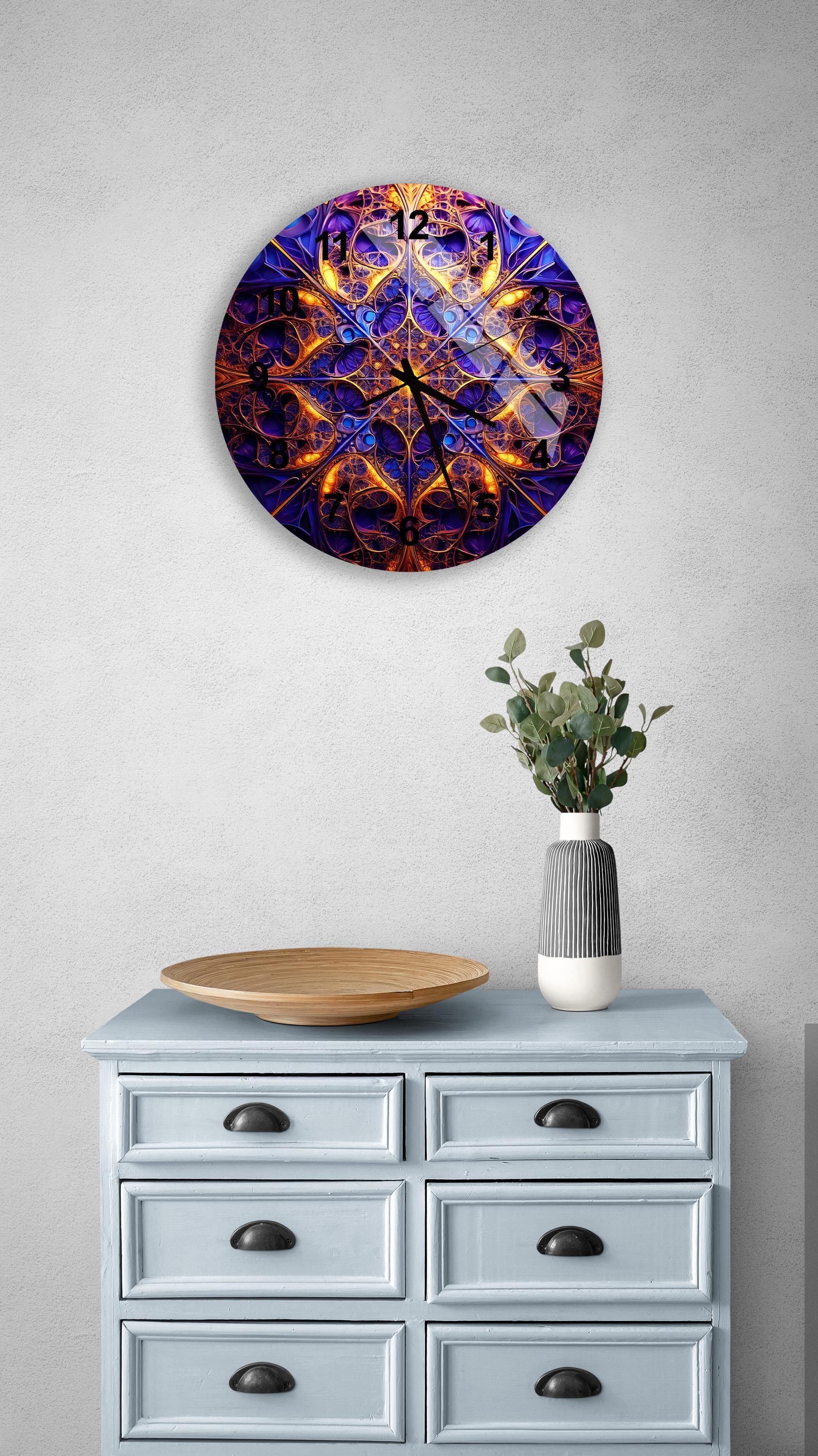 a blue and orange clock on a wall above a dresser