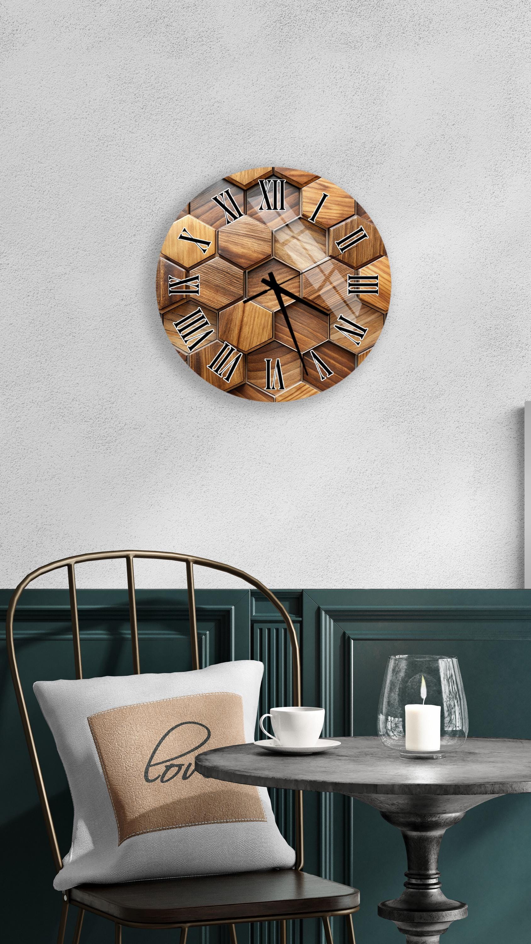a wooden hexagonal clock mounted on a wall above a table with a white tablecloth. The table has a glass candle and a white coffee cup on it.