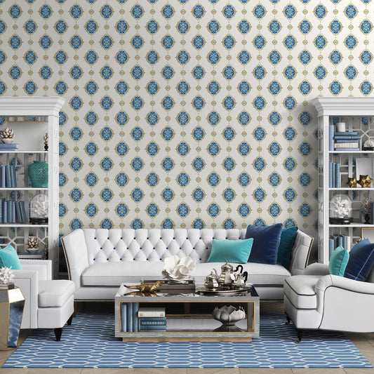 a modern living room with a white tufted sofa, a white armchair, and a glass coffee table. The room is decorated with blue and white patterned wallpaper, and there are several bookshelves and decorative items, such as vases and figurines, adding to the overall aesthetic.