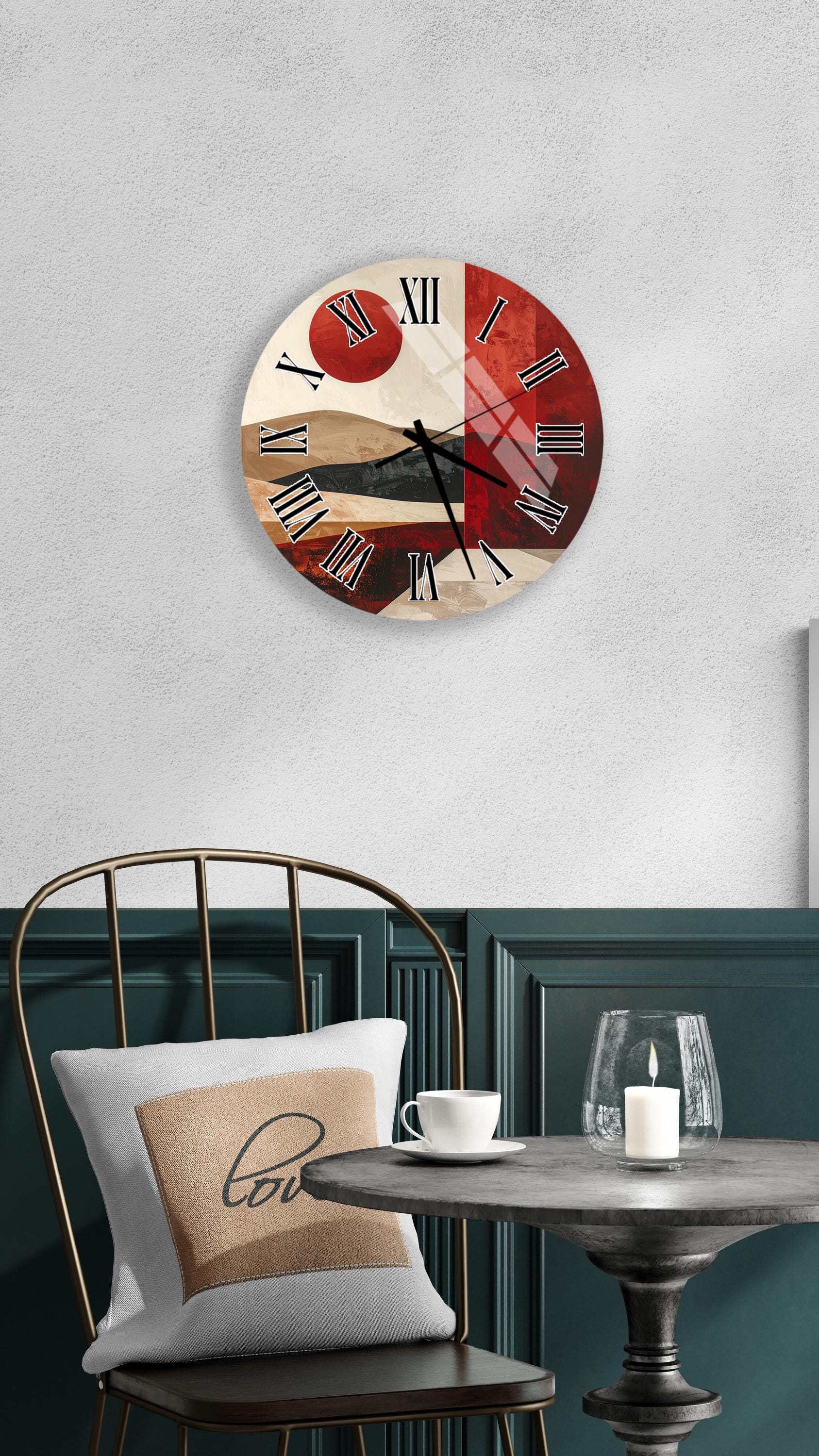 a modern wall clock with a red and white color scheme, mounted on a wall above a dining table with a white tablecloth. The table is set with a white cup and a candle, creating a cozy and inviting atmosphere.