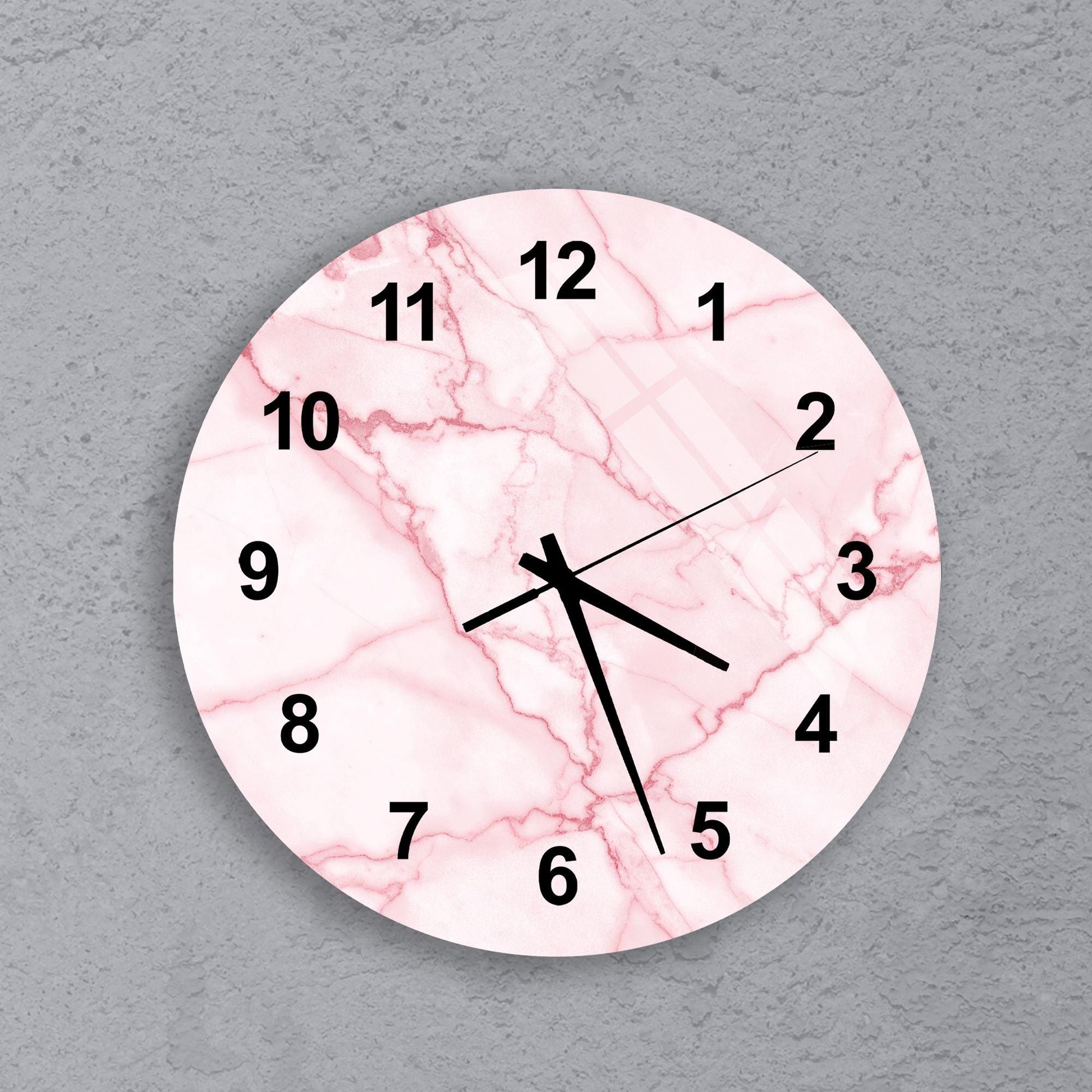 A pink marble-like clock face with black numbers and hands is displayed against a gray background.