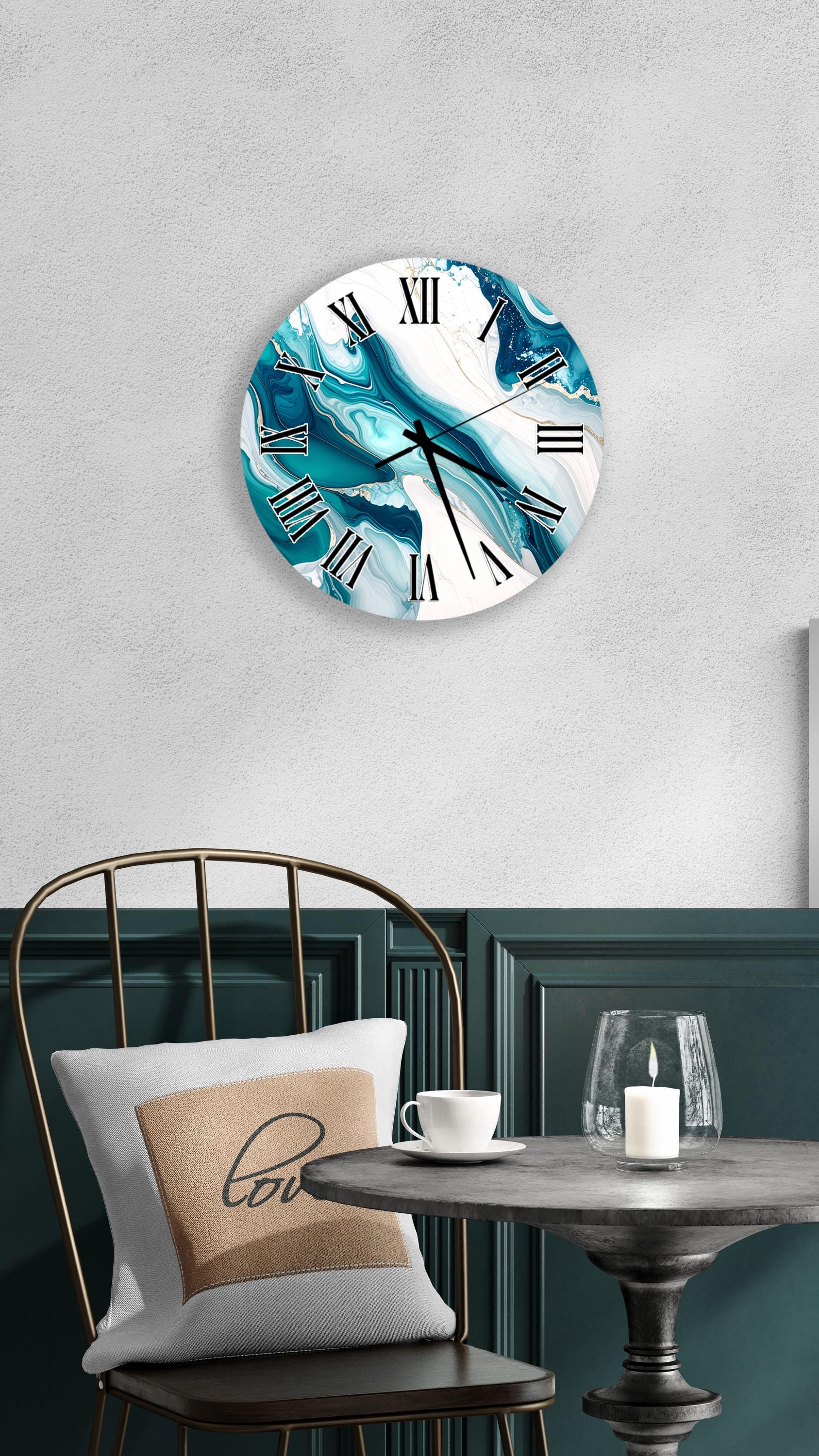a modern and stylish interior design with a round wall clock displaying a blue and white marble pattern, a white table with a candle and a cup, and a black metal chair with a white pillow.