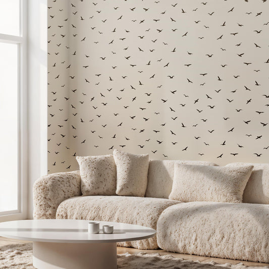 a cozy living room with a plush white sofa, a round coffee table, and a wall adorned with a repeating pattern of black birds.