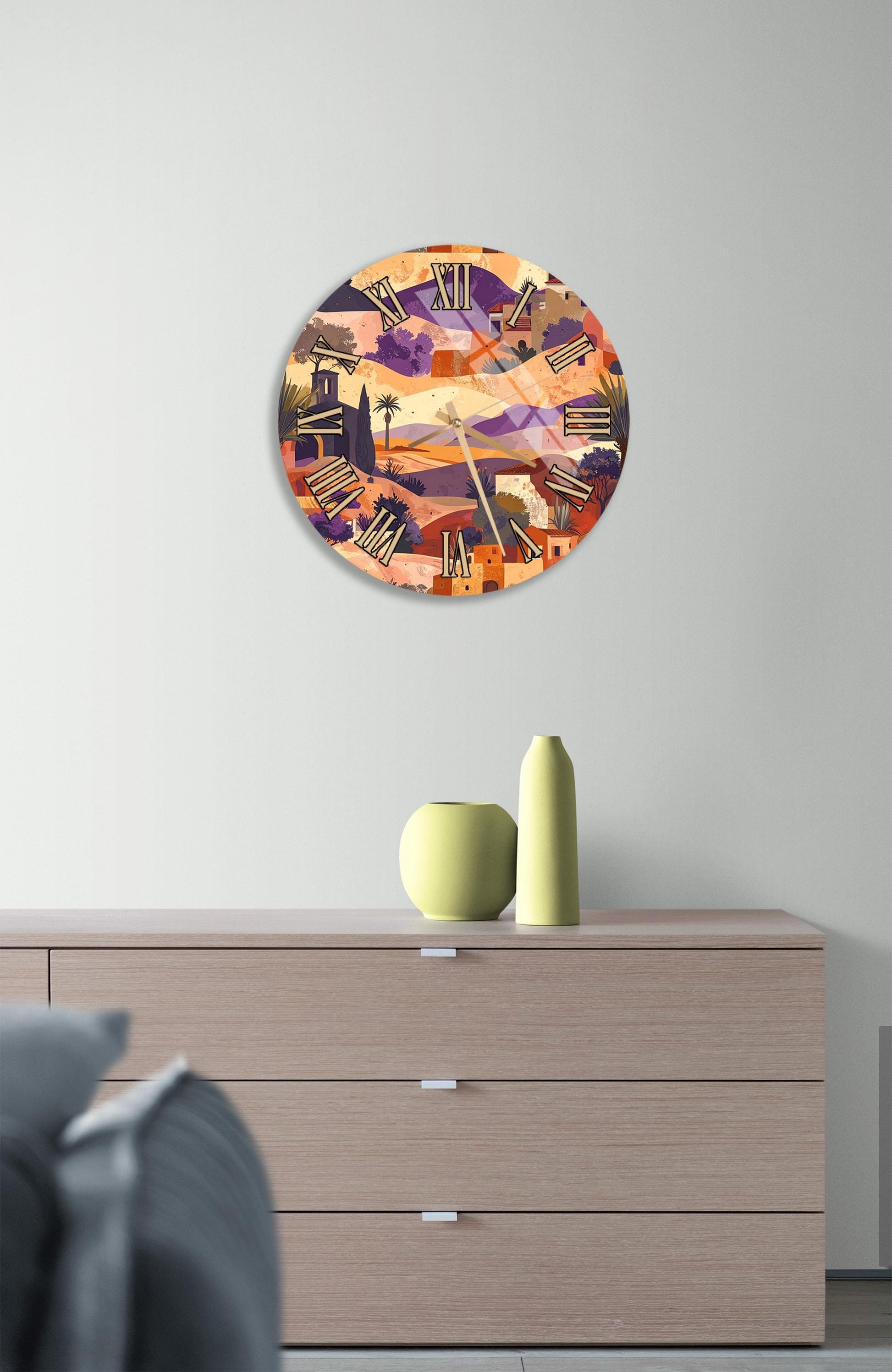 a wall clock with a colorful, abstract design hanging above a wooden dresser with three drawers.