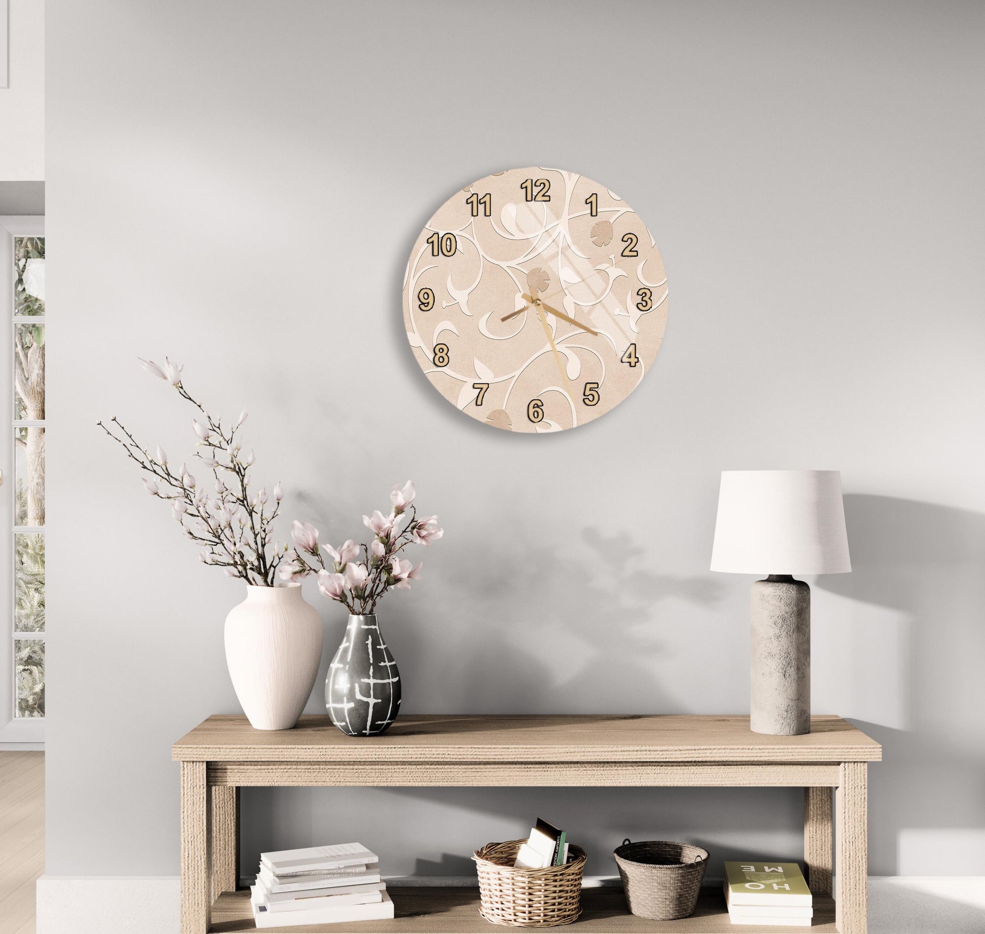 a wall clock with a floral design, a wooden table with a lamp, a vase with flowers, and some books on a shelf.