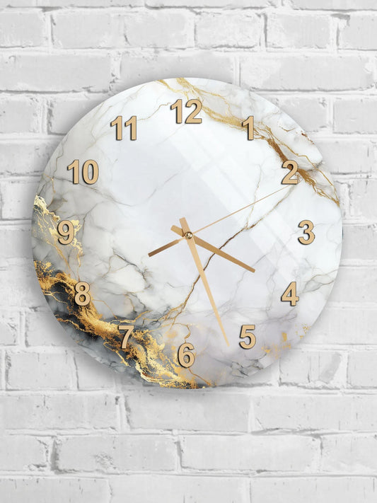 A round wall clock with a marble-like design and gold numbers is mounted on a white brick wall.