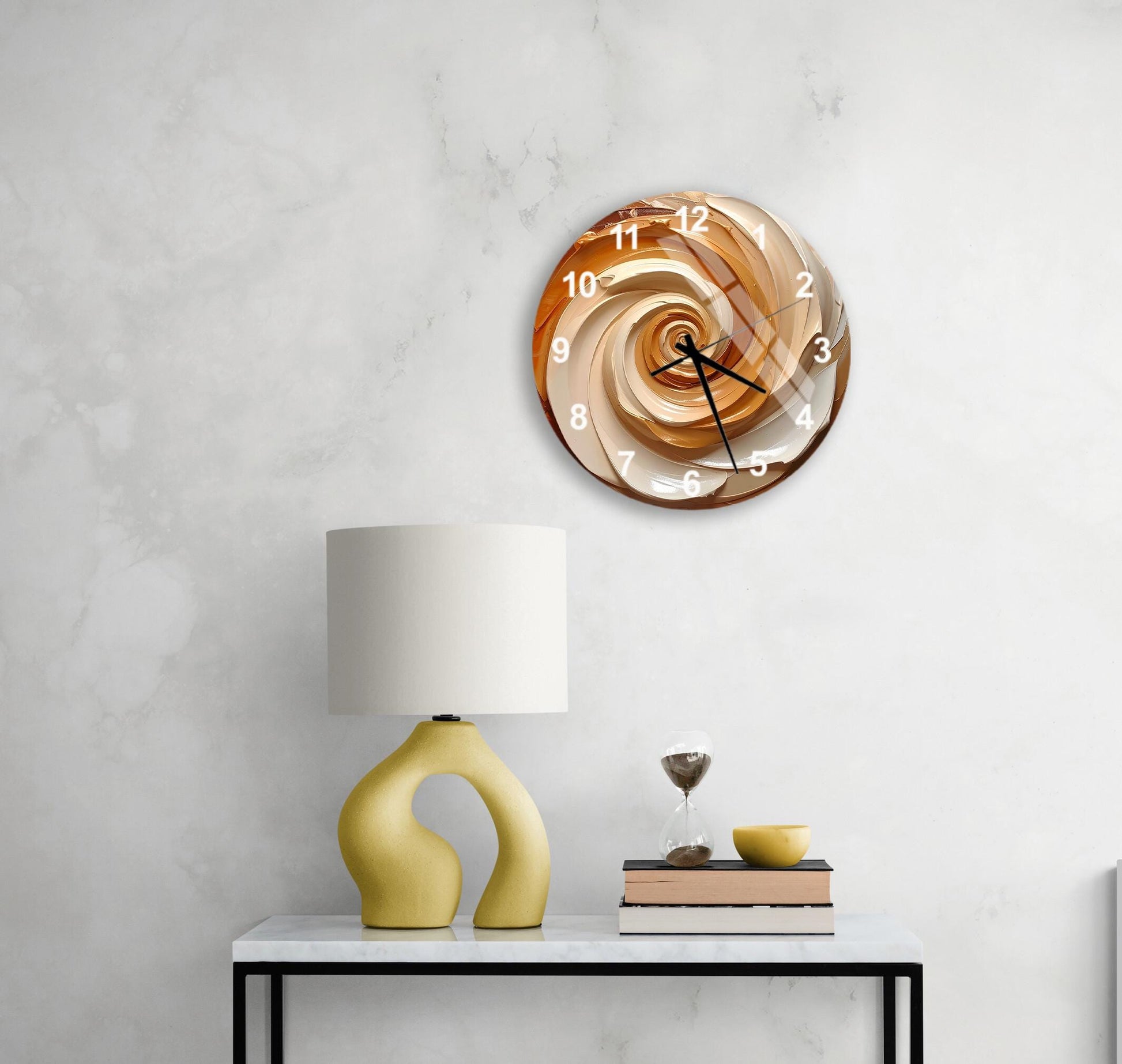 a modern, abstract wall clock with a spiral design, mounted on a white wall above a white table with a yellow lamp and a stack of books.