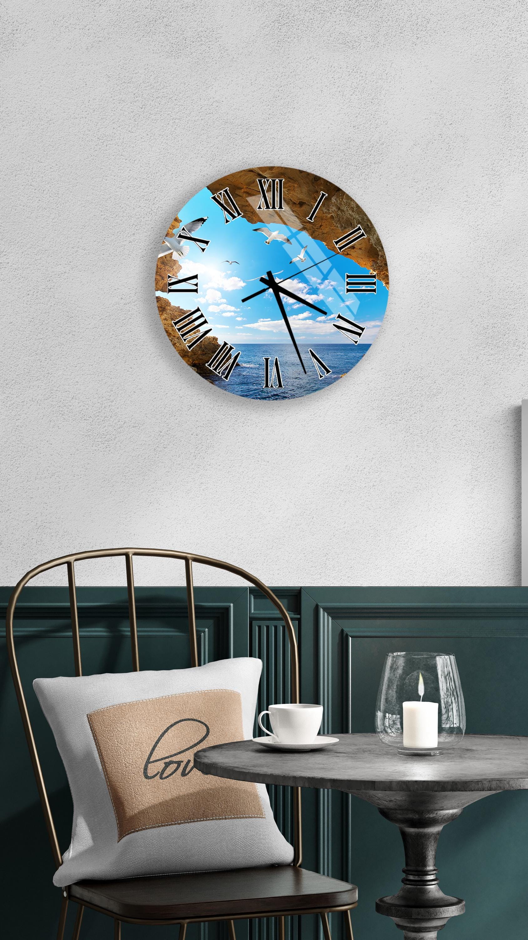 a wall clock with a beach scene on its face, mounted on a wall above a table with a white tablecloth.
