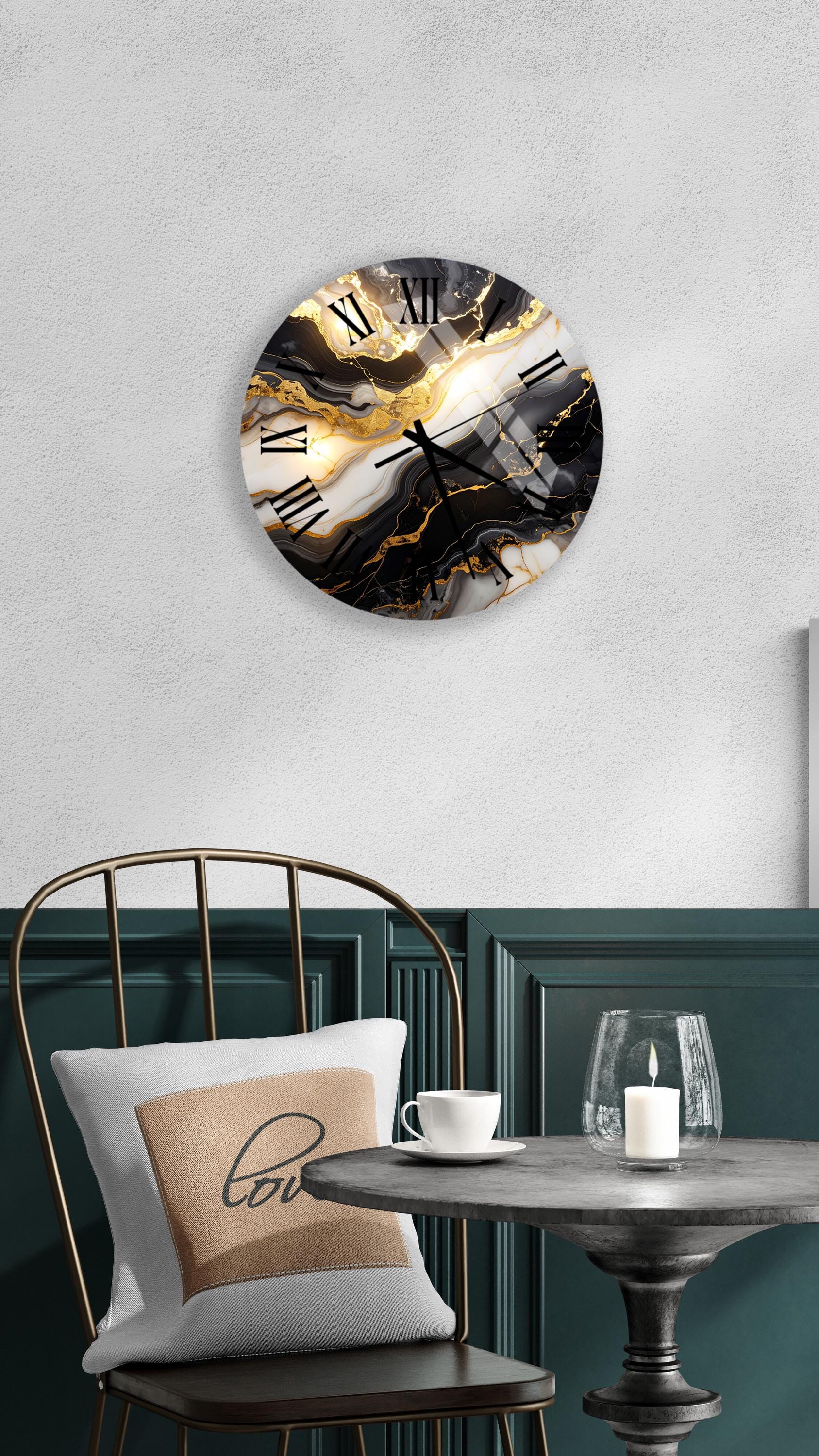 a modern and stylish interior design with a round wall clock featuring a marble-like pattern in gold and black colors, a white table with a candle and a cup, and a black metal chair with a white pillow.