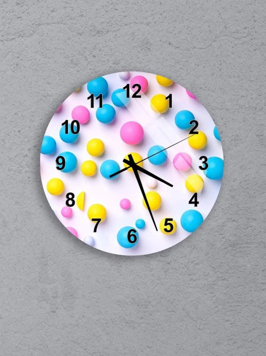 six colorful clocks with various designs and patterns, including balloons and numbers, mounted on a gray wall.