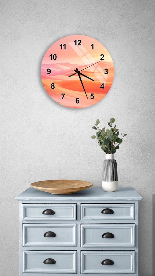 a wall clock with a sunset-themed design, mounted on a wall above a wooden dresser with drawers. The dresser also has a vase with greenery and a wooden tray on top.