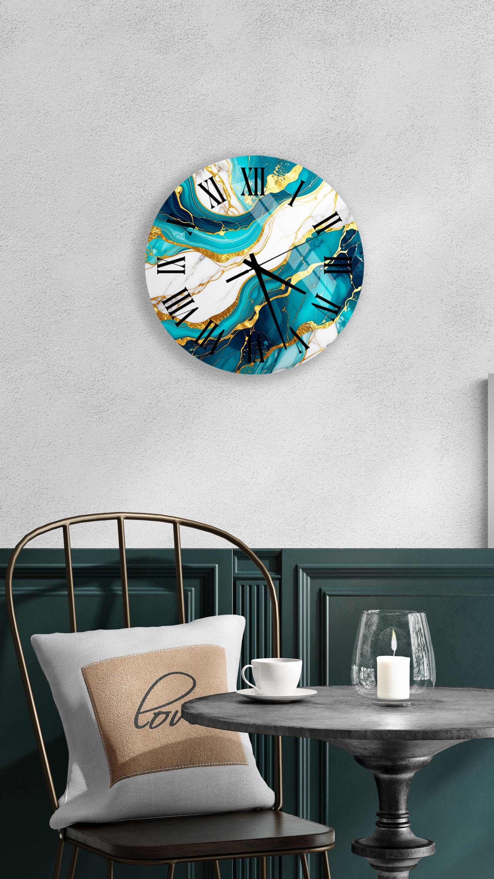 a modern and stylish interior design with a round wall clock featuring a marble-like pattern in shades of blue and gold, hanging above a table with a white tablecloth and a candle.