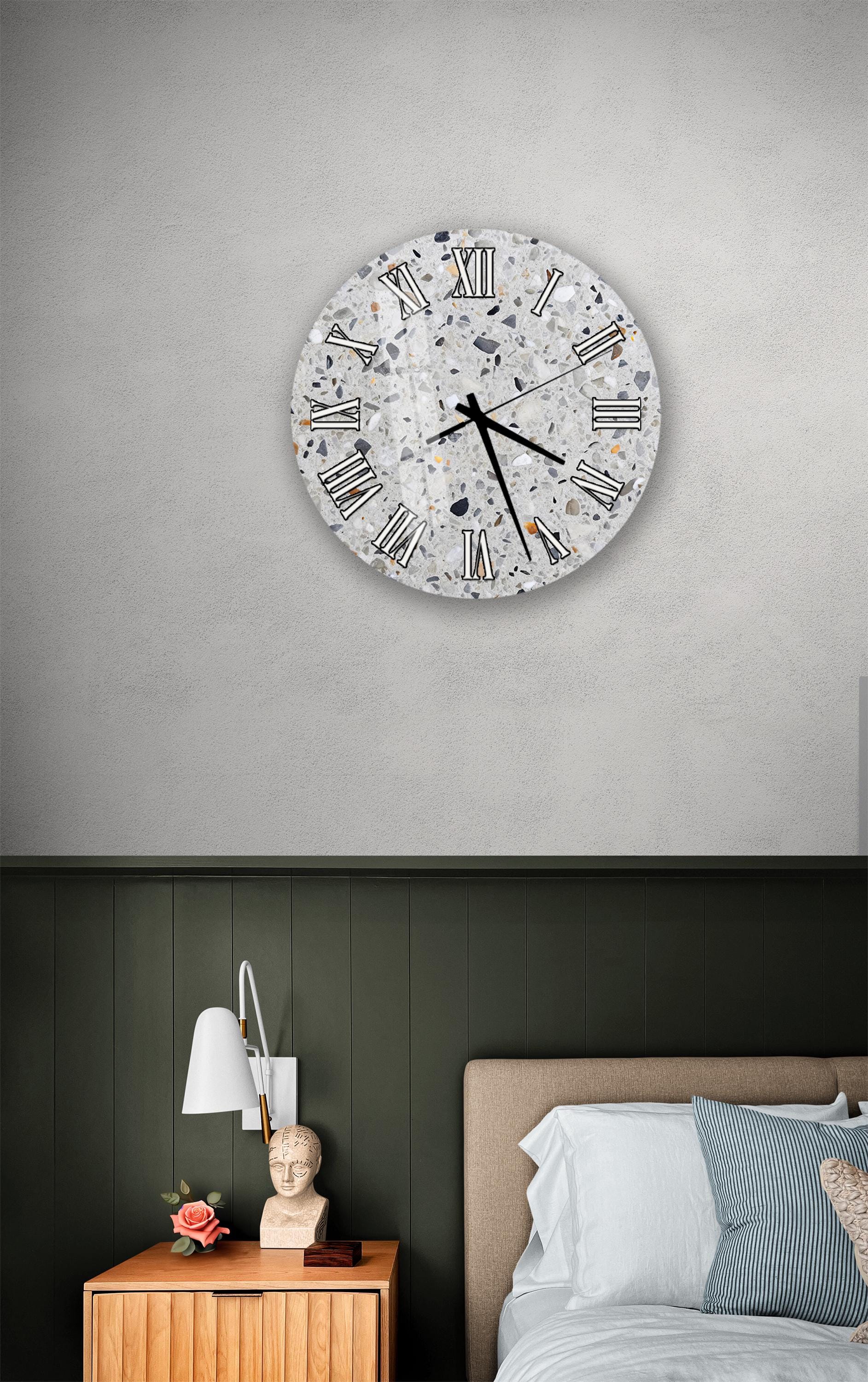 a bedroom setting with a large wall clock, a wooden nightstand, and a bed with white pillows.