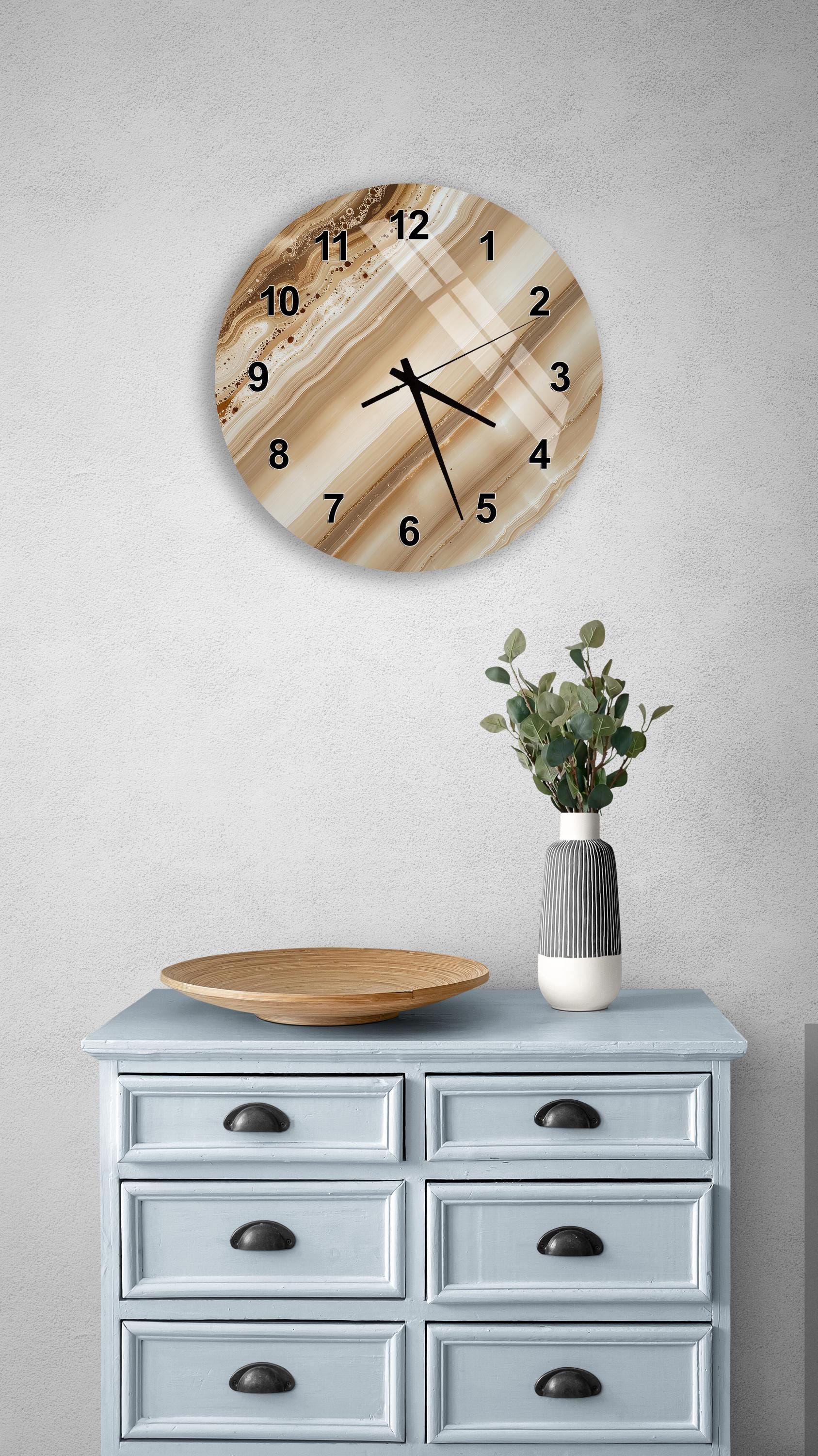 a wall clock with a wooden frame, a wooden tray, a vase with greenery, and a light blue dresser with six drawers.