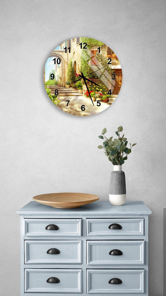 a wall clock with a scenic outdoor view, a wooden tray, a vase with greenery, and a gray dresser with six drawers.