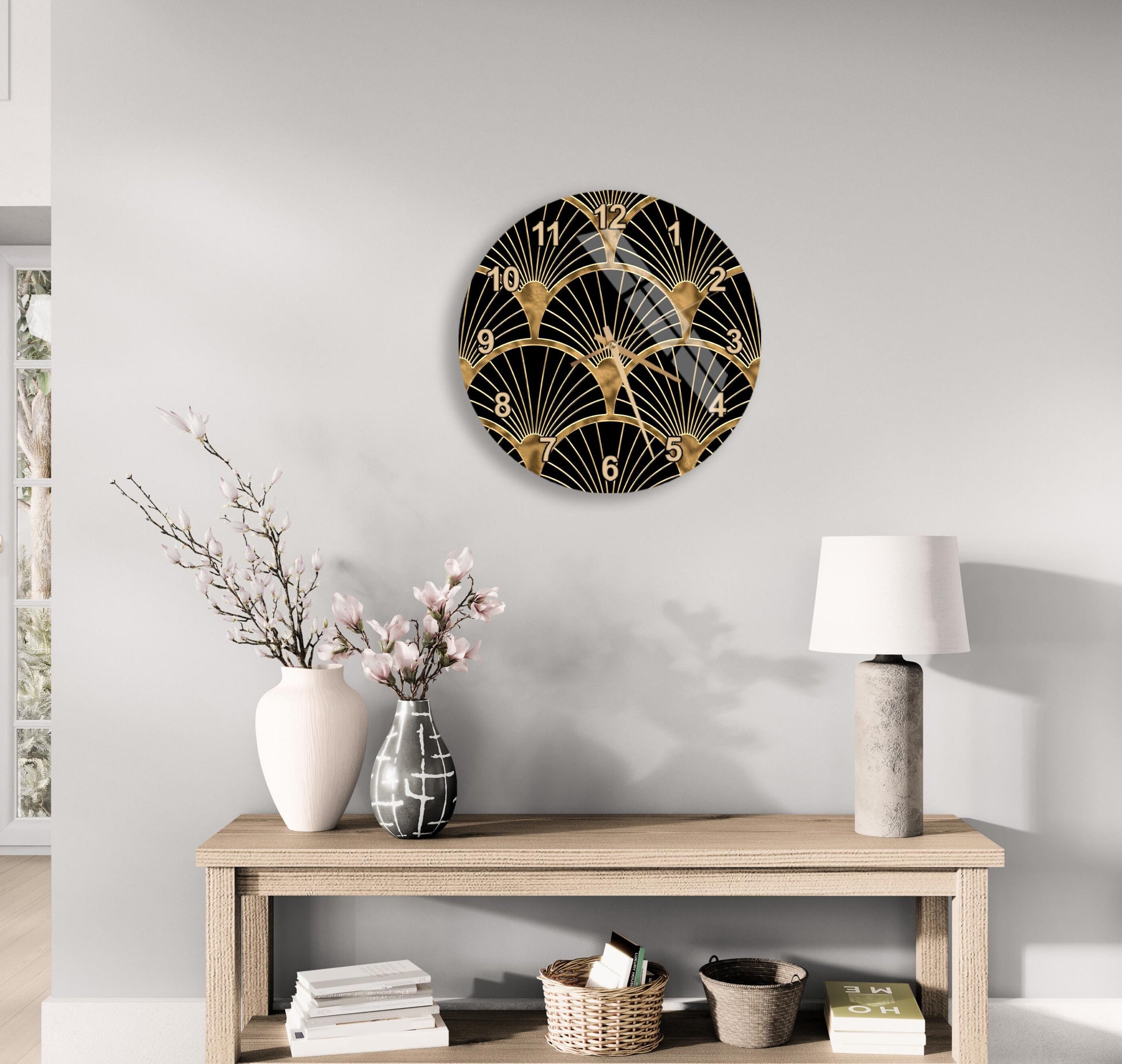 a modern living room with a wooden console table, a round wall clock with a black and gold design, a vase with pink flowers, and a lamp on the table.