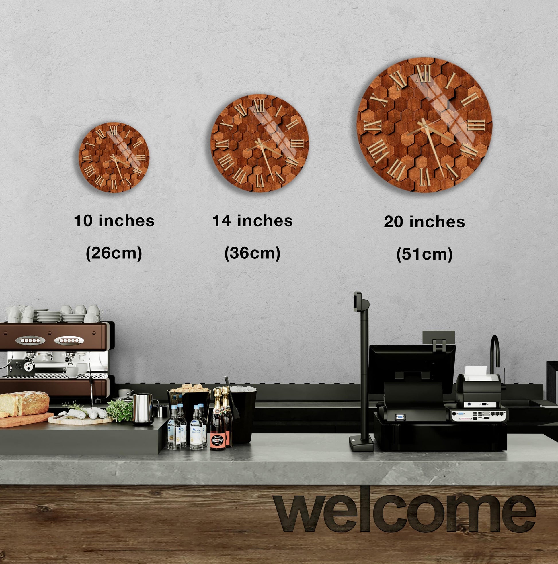 a wall with three different clock designs, each representing a different size: 10 inches, 14 inches, and 20 inches. Below the clocks, there is a counter with various items such as bottles and a sandwich. The word "welcome" is also visible in the image.
