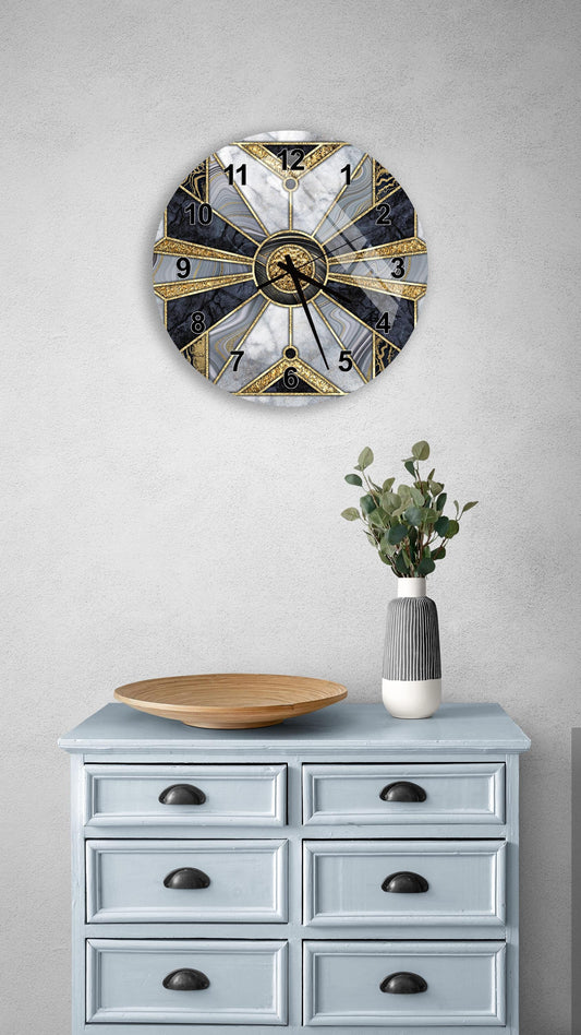 a wall clock with a marble and gold design, mounted on a wall above a light blue dresser with six drawers. The dresser also has a vase with greenery on it, and a wooden bowl on top.