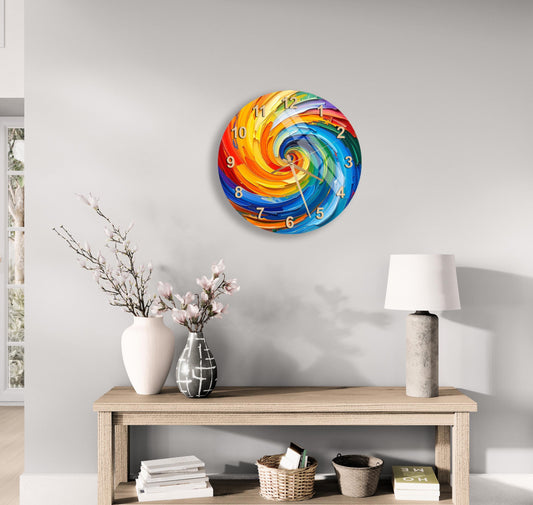 a wall clock with a colorful spiral design, a wooden table with a lamp, a vase with flowers, and some books on a shelf.