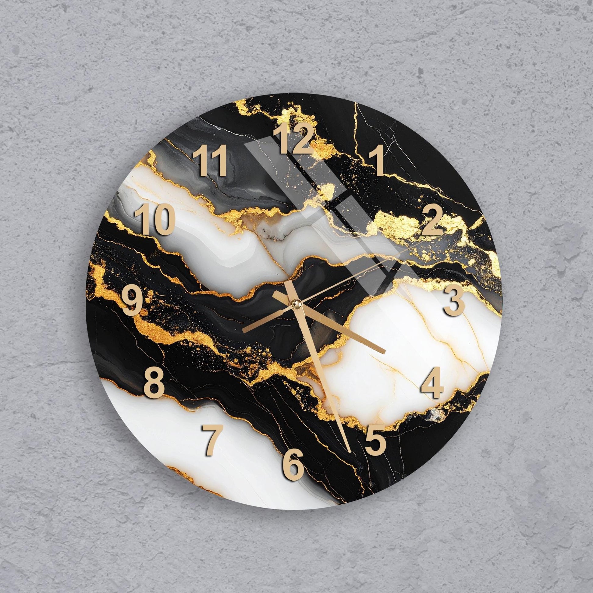 A wall clock with a marble-like design featuring black, white, and gold colors.