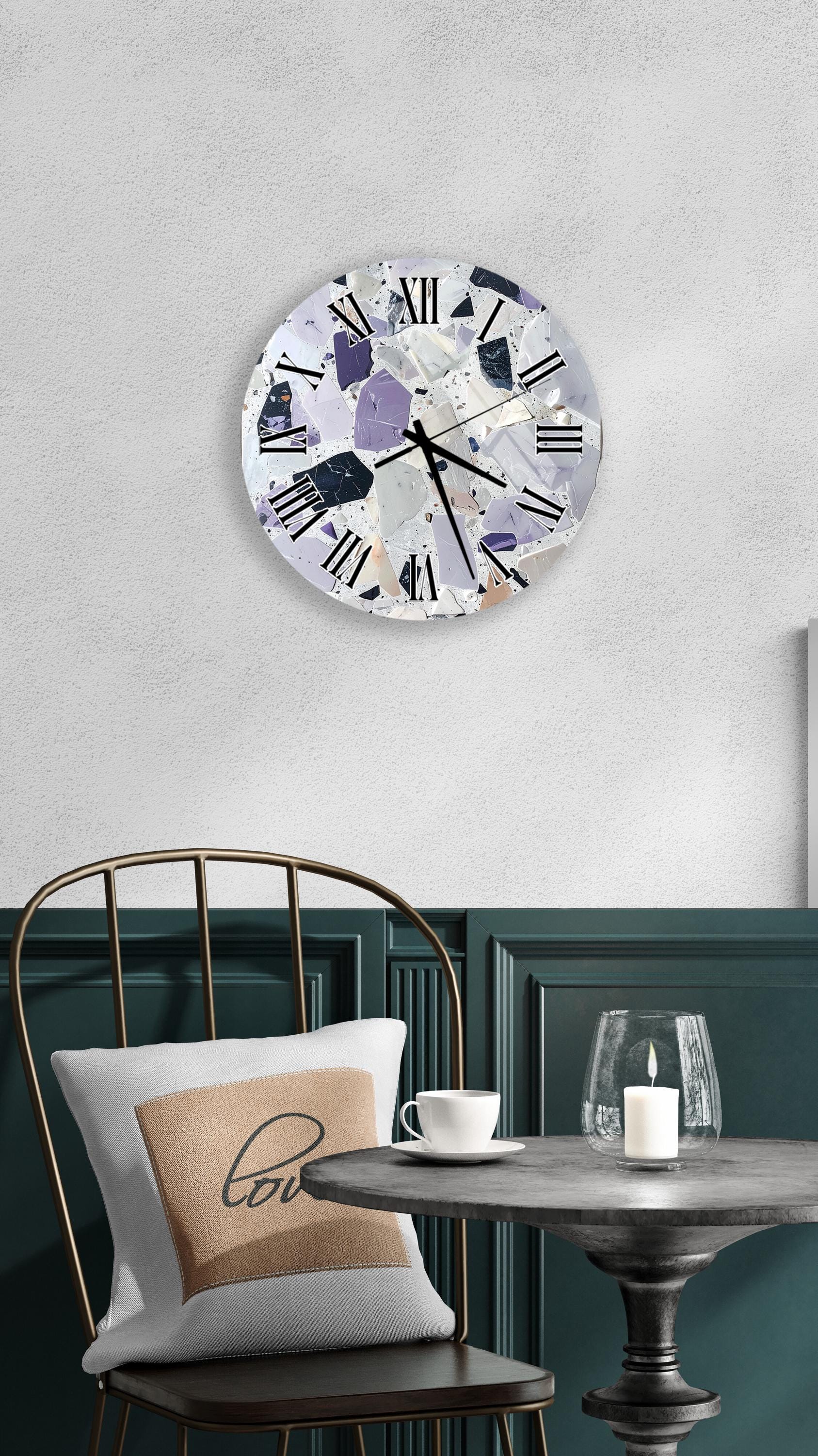 a modern and stylish interior design with a round clock featuring a mosaic-like pattern on the wall above a dining table with a white tablecloth. The table is set with a white cup and a candle, creating a cozy and inviting atmosphere.
