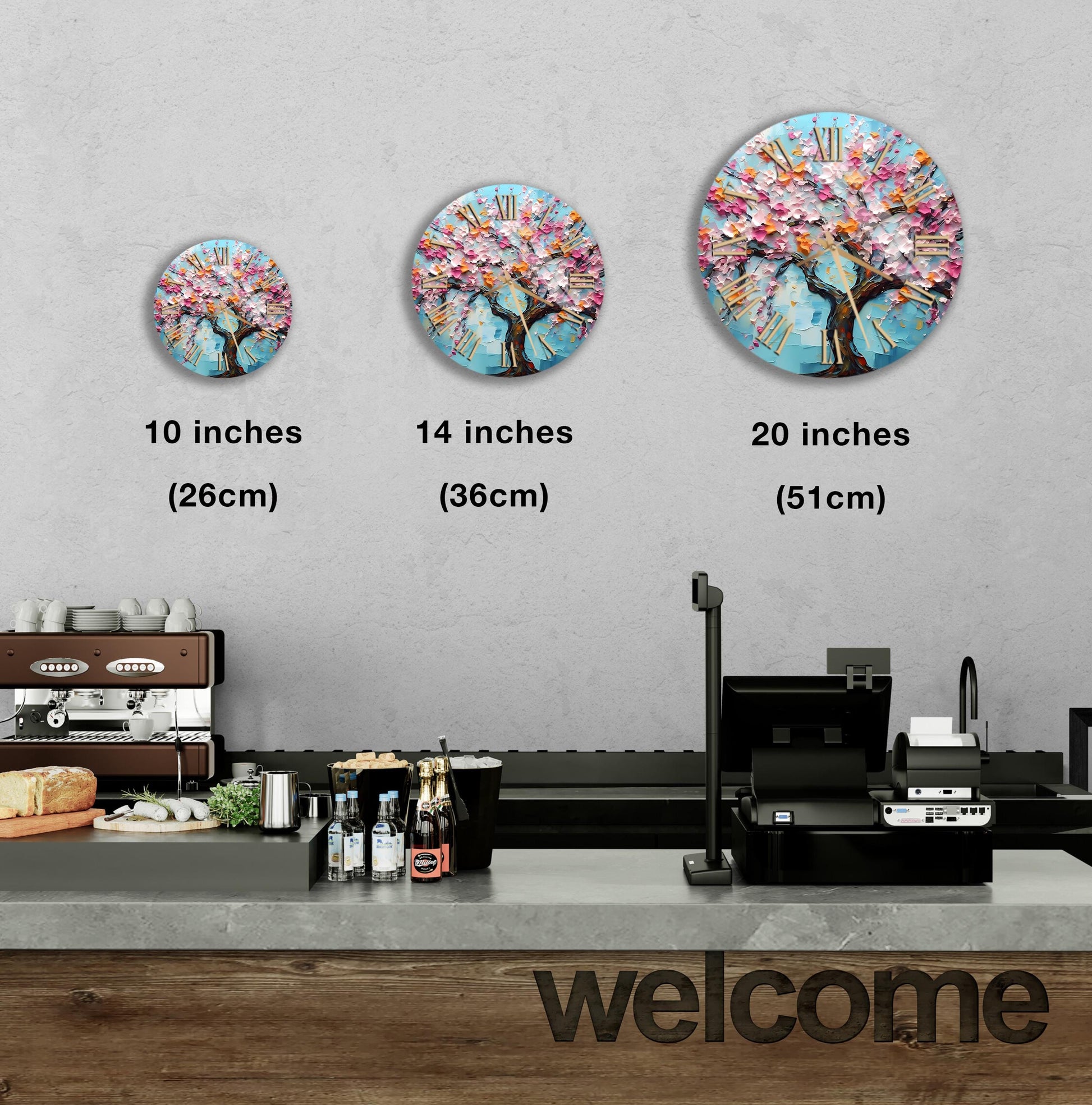A wall clock with a tree design is displayed in three different sizes, ranging from 10 inches to 20 inches. Below the clock, there is a counter with various items such as bottles and a cash register. The word "welcome" is written on the counter.