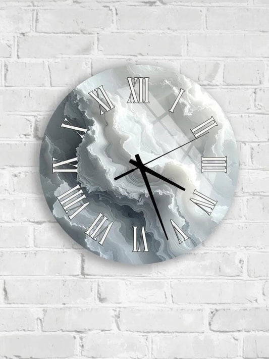 A wall clock with Roman numerals and a cloud-like design on its face is mounted on a white brick wall.