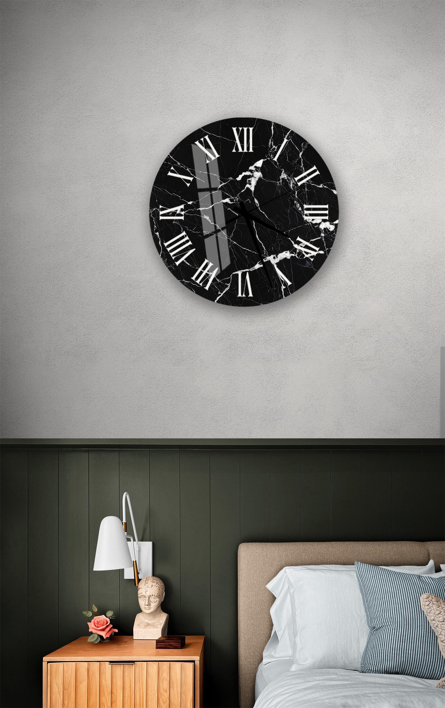 a bedroom setting with a black and white marble clock on the wall above a bed with a wooden headboard.