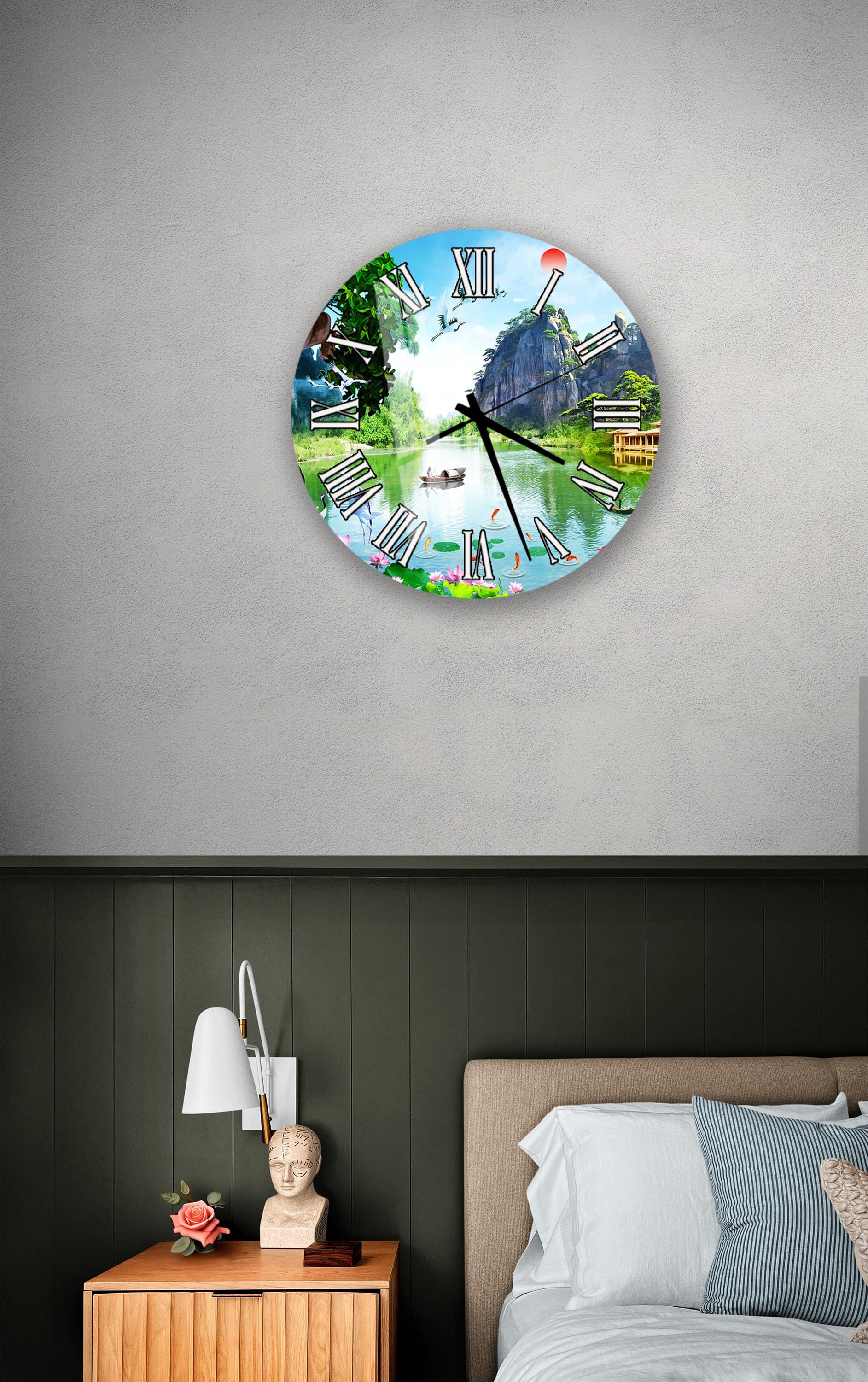 a clock with a scenic landscape design on its face, mounted on a wall above a bedside table with a lamp and a small statue.