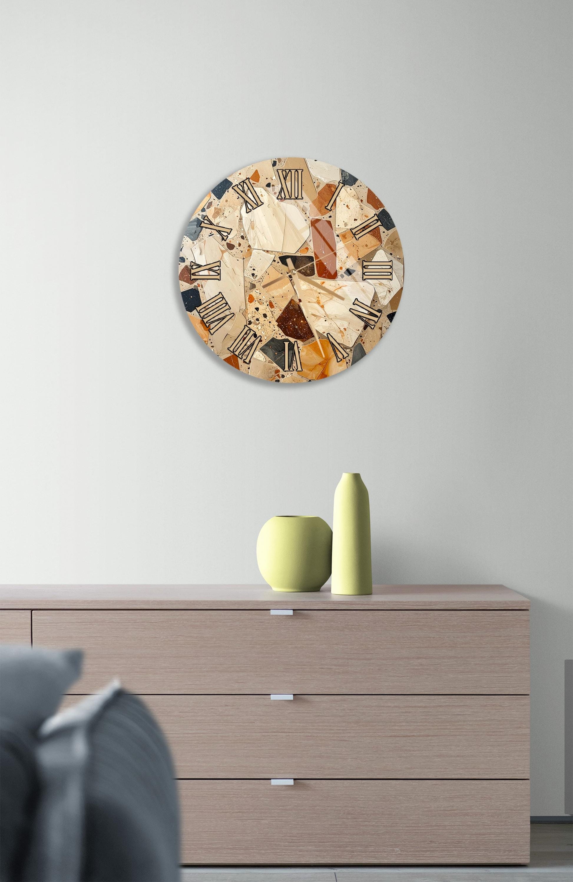 a modern interior design with a round clock on the wall above a wooden dresser. The dresser has three drawers and a vase on top.