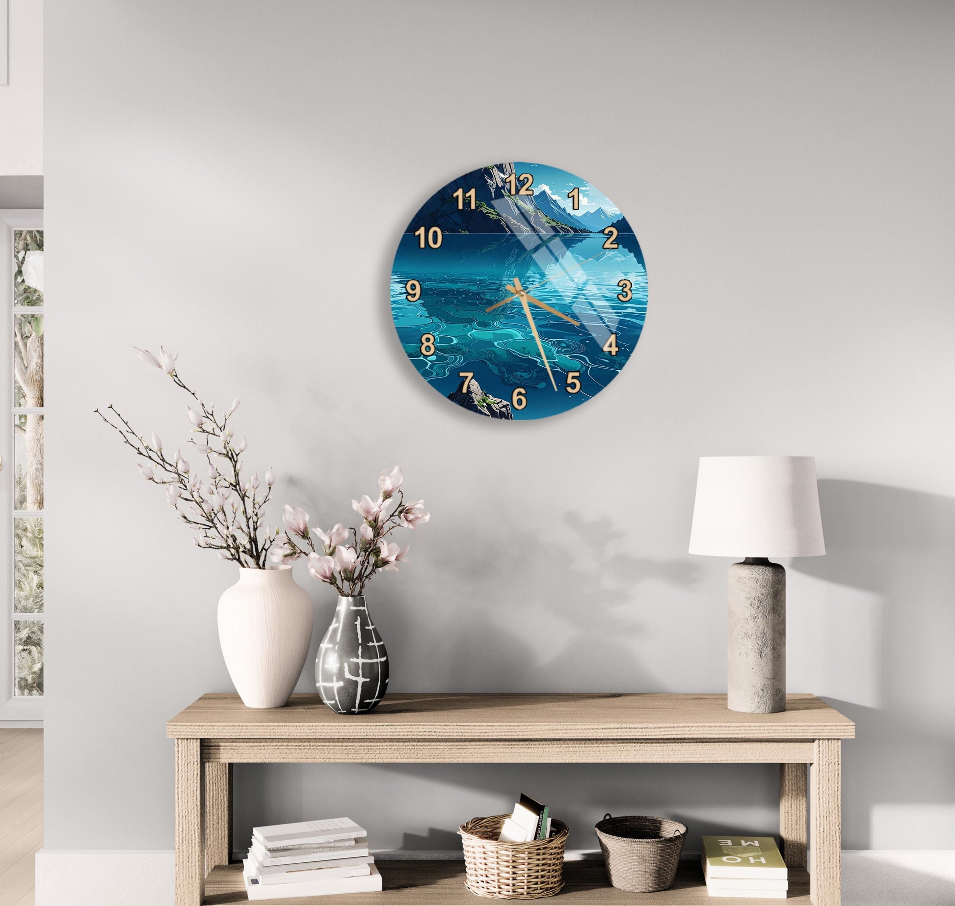a wall clock with a blue ocean scene, a wooden table with a lamp, a vase with pink flowers, and a stack of books.