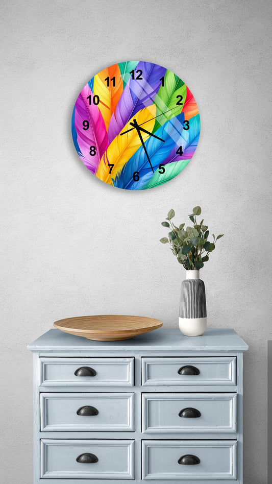 a colorful wall clock with a feather design, mounted on a wall above a light blue dresser with six drawers. The dresser also has a small plant and a wooden bowl on it.