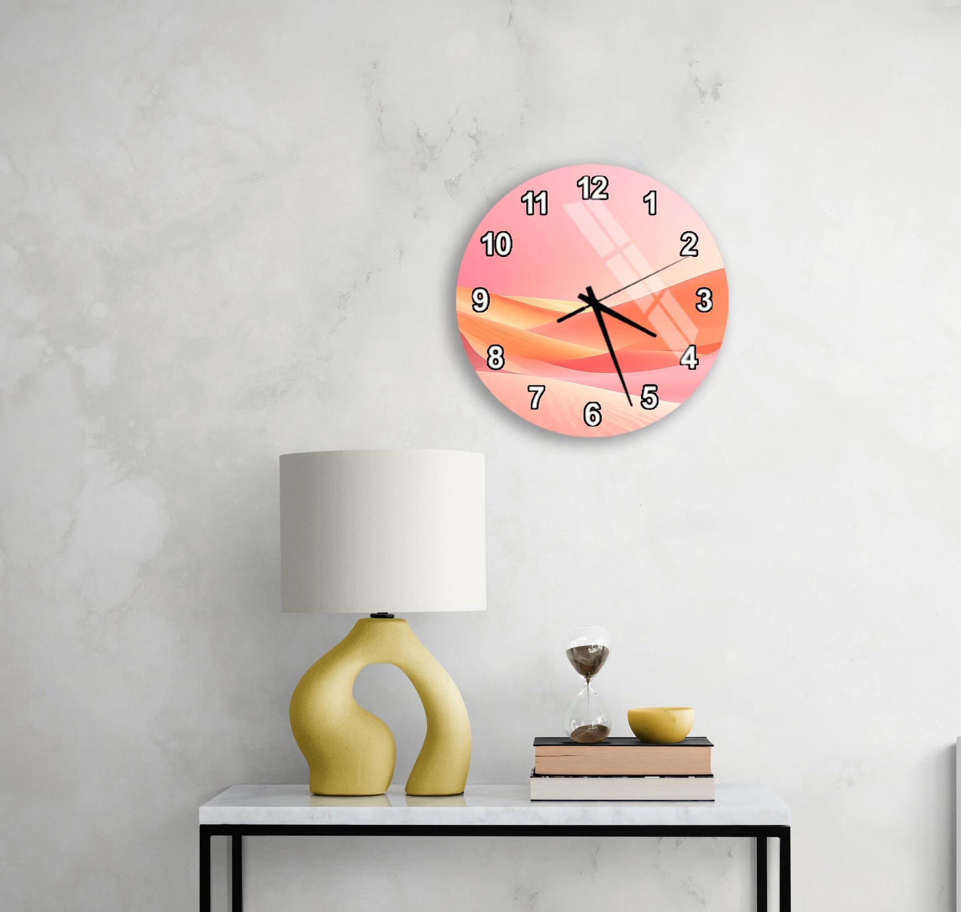 a modern, minimalist living space with a white wall, a round clock with a pink and orange design, a yellow lamp with a unique, curved base, and a small table with a book and a glass of water.