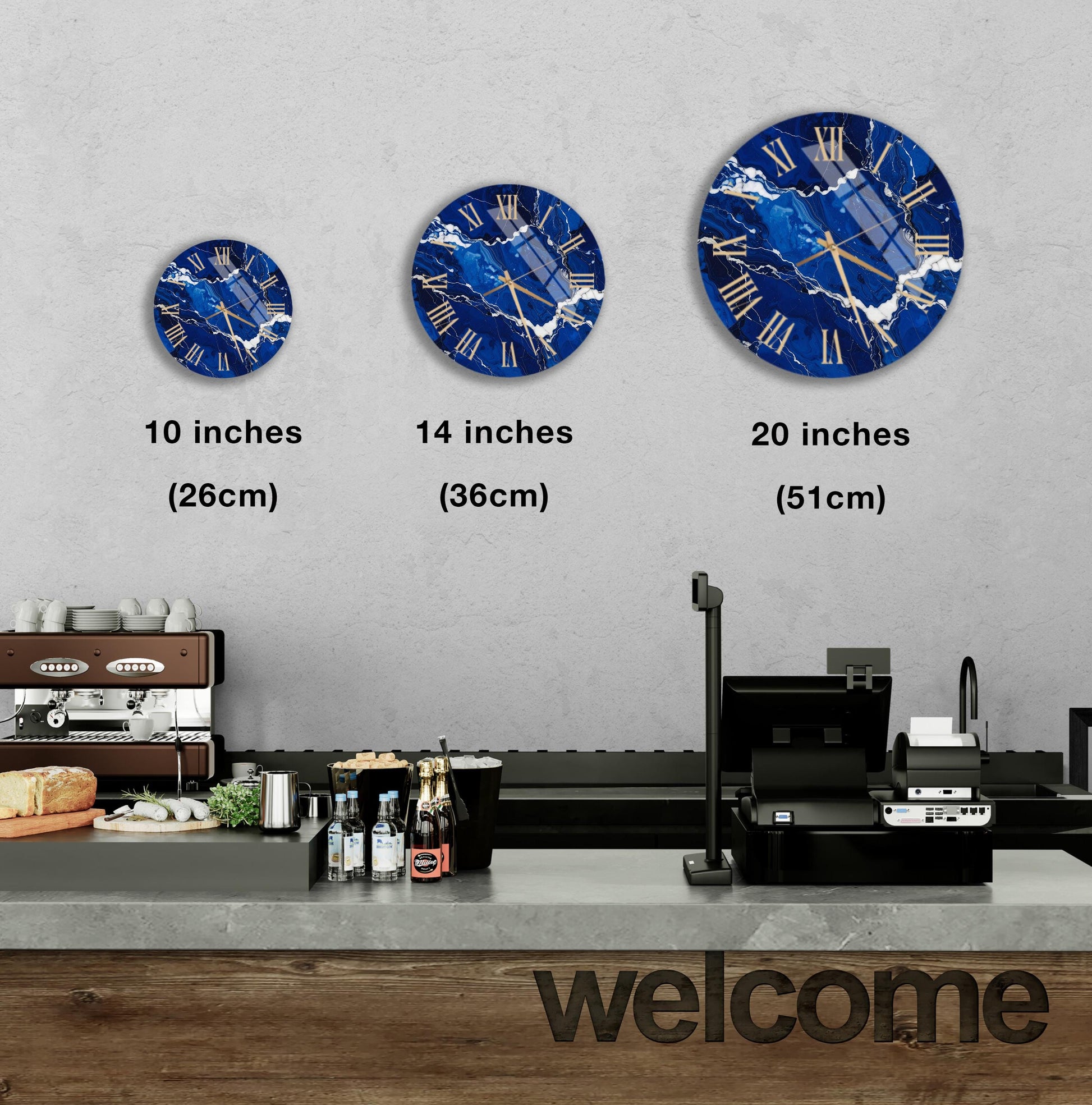 a wall with three clock faces of different sizes, each displaying a blue marble design. Below the clock faces, there is a counter with various items such as bottles and a sandwich. The word "welcome" is written on the counter.