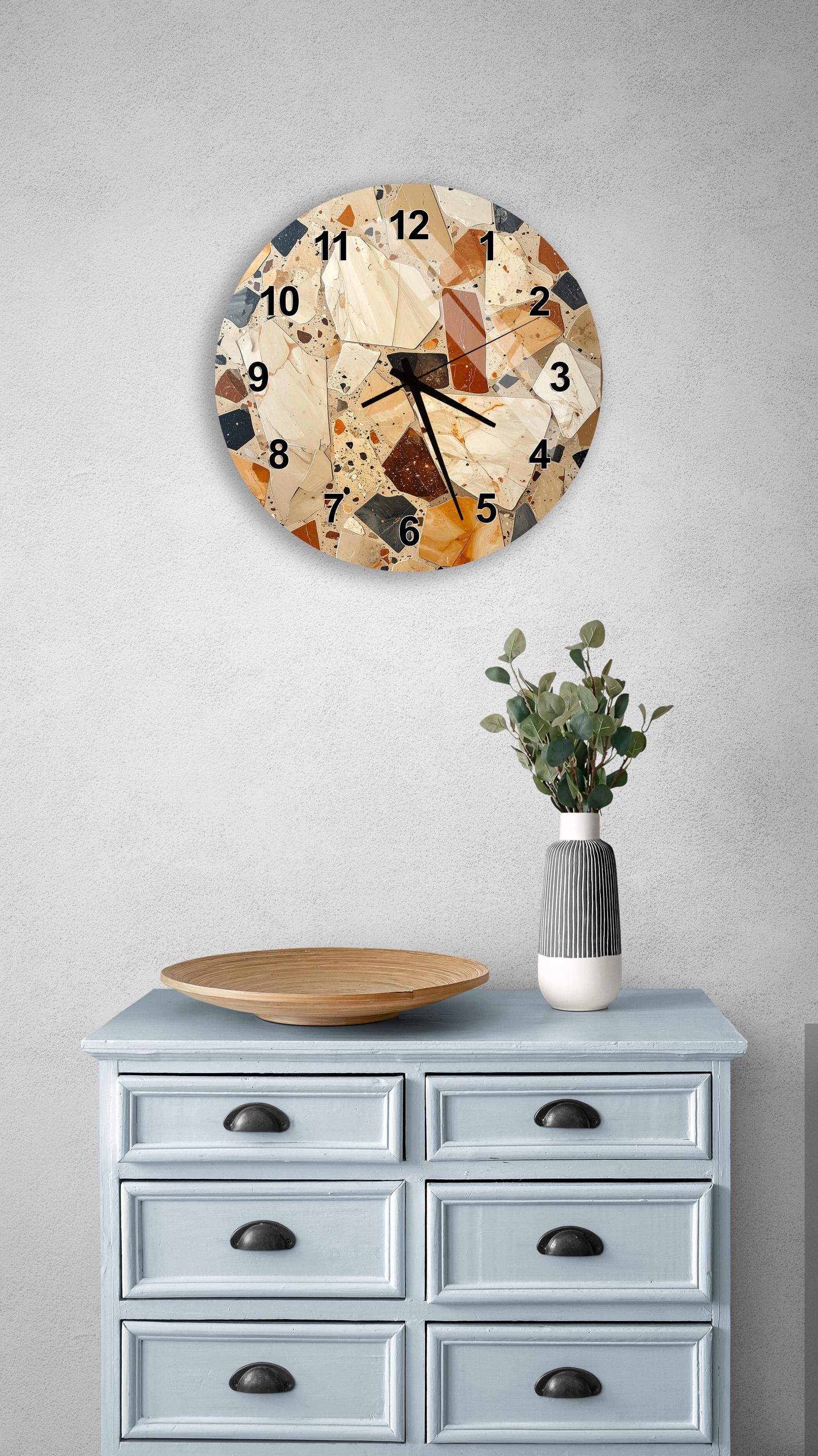 a wall clock with a mosaic design, a wooden tray, a vase with greenery, and a light blue dresser with six drawers.