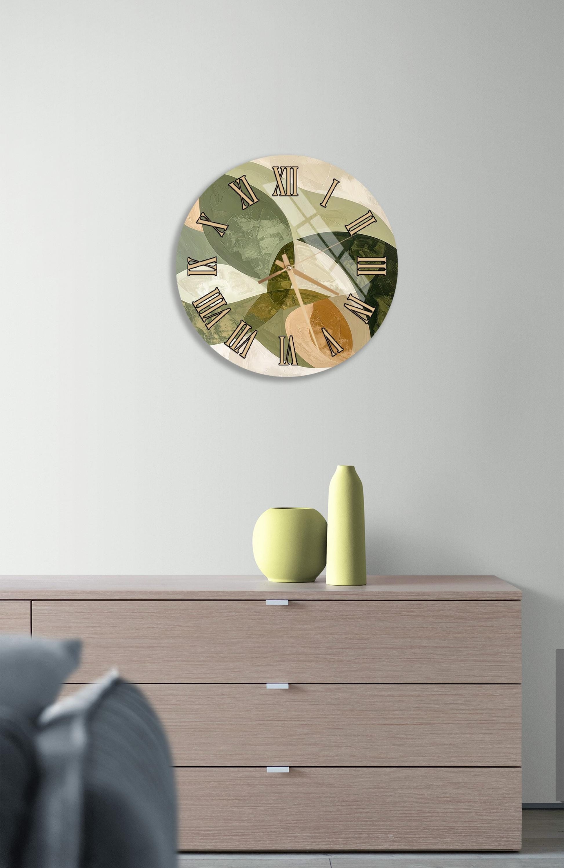 a modern living room with a round wall clock displaying Roman numerals, a wooden dresser with a vase and a small plant, and a gray couch in the background.