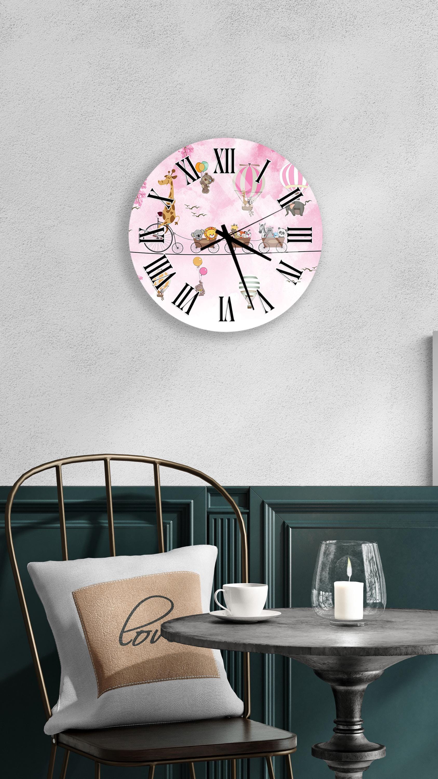 a wall clock with a pink and white design, a white table with a candle and a cup, and a green chair with a pillow.