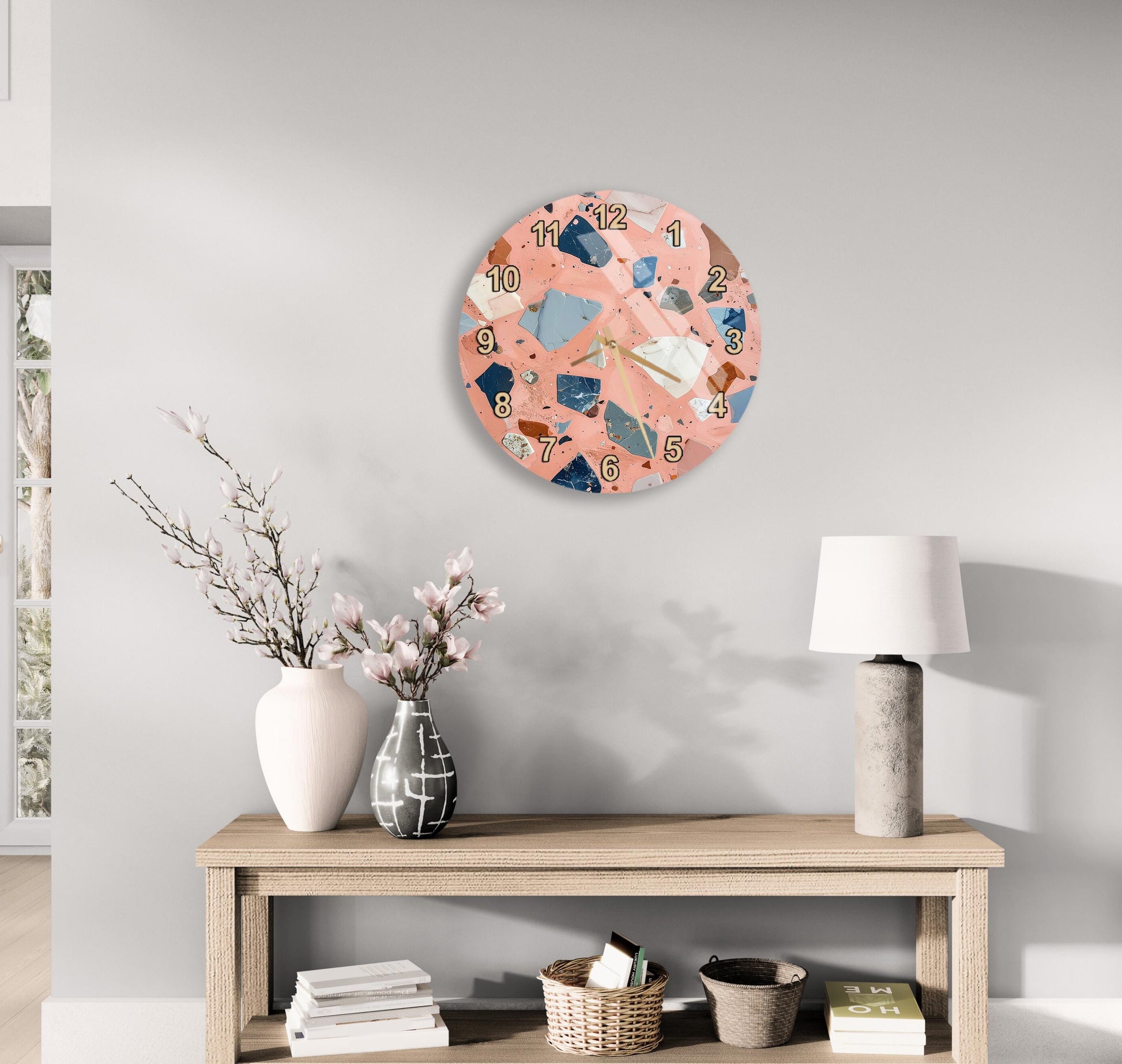 a wooden table with a lamp, a vase with flowers, and a clock on the wall above it.