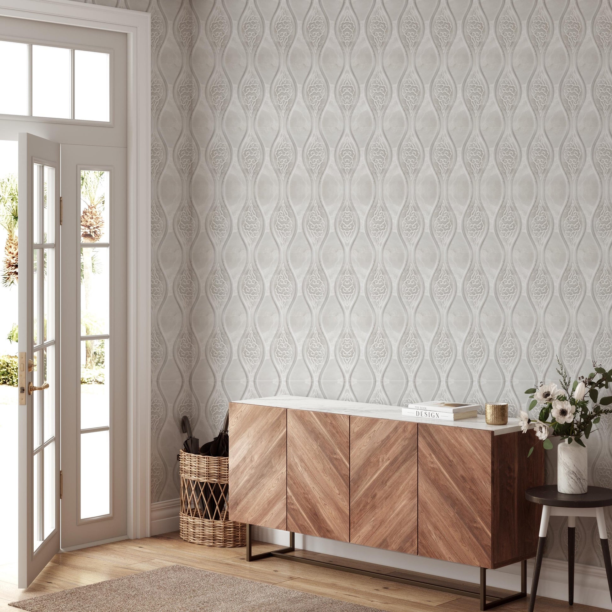 a modern and minimalist interior design with a large wooden cabinet, a wicker basket, and a vase of flowers. The cabinet has a white countertop and a glass door, and the wicker basket is placed next to the cabinet. The vase of flowers adds a touch of natural beauty to the space. The walls are covered in a patterned wallpaper, and the room is well-lit, creating a bright and airy atmosphere.
