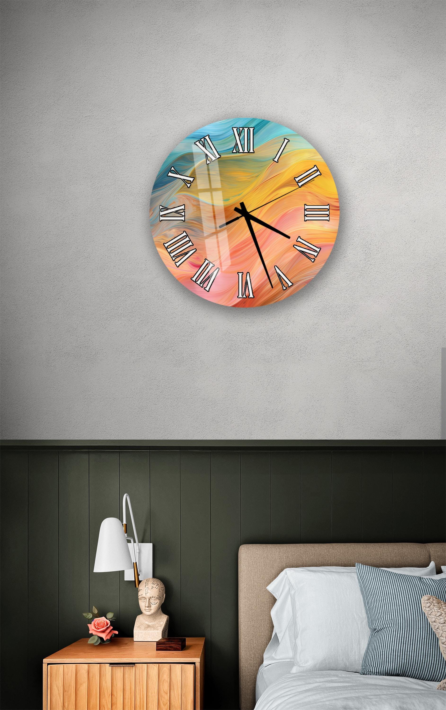 a bedroom setting with a colorful wall clock hanging above a bed. The clock has a vibrant design with a rainbow-colored background and Roman numerals. The room also includes a nightstand with a lamp and a small statue or bust.