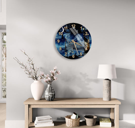 a wall clock with a blue and white design, mounted on a wall above a wooden table with various decorative items, including a vase with flowers, a lamp, and a stack of books.